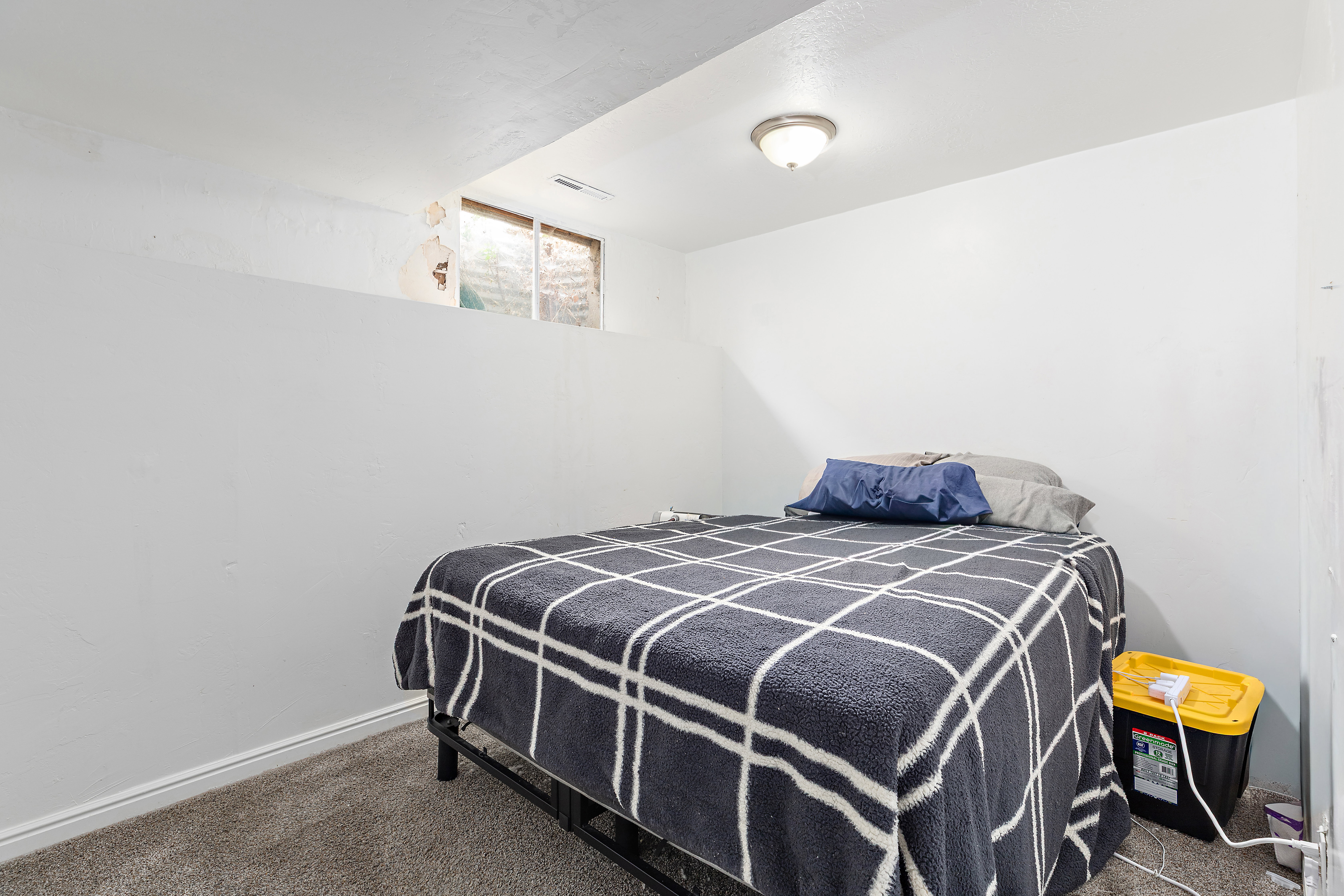 Carpeted room with a flush-mount ceiling light fixture, white walls, and a single window
