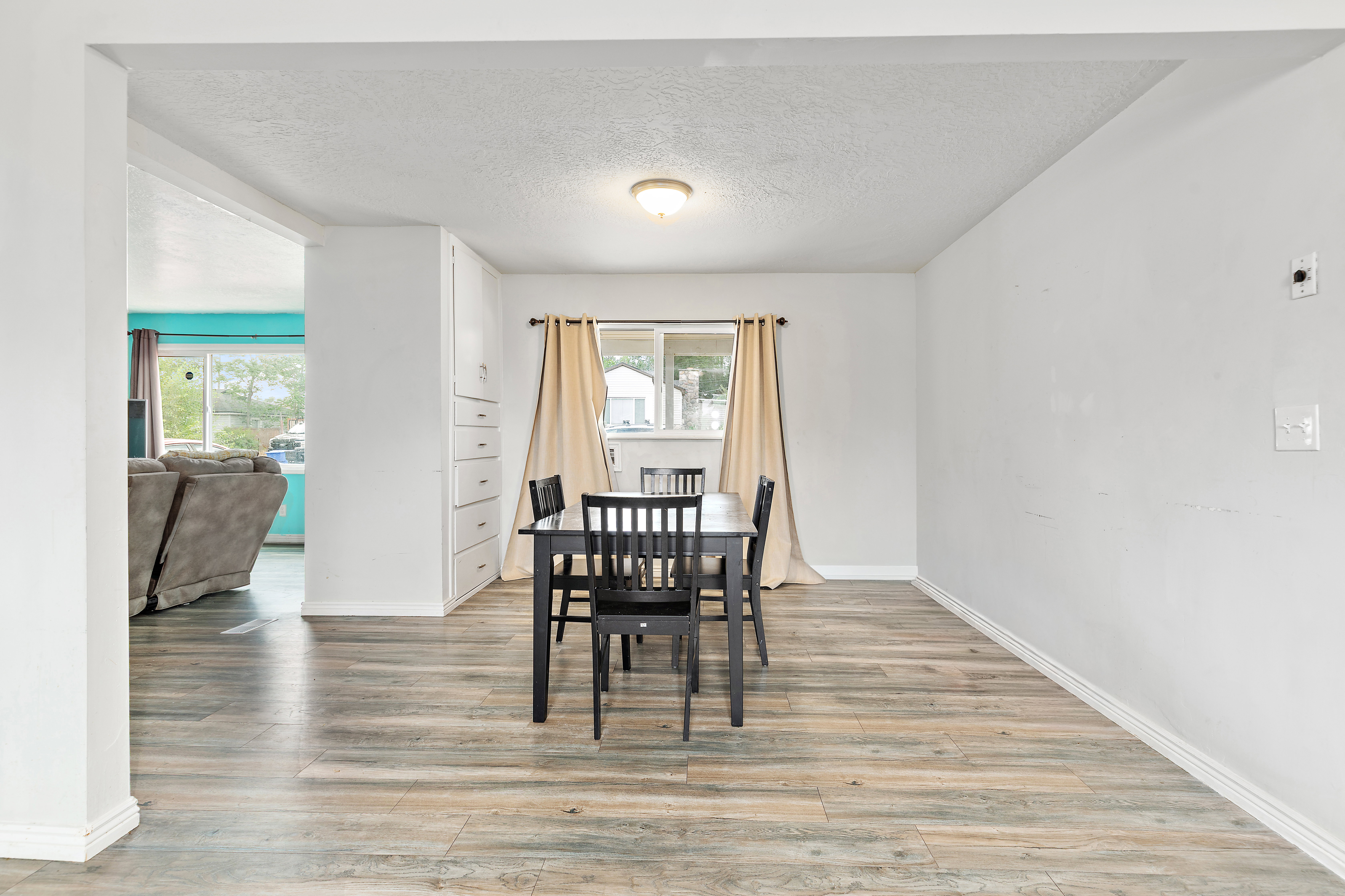 Bright interior space featuring wood-finish flooring, a recessed window, and built-in cabinetry with multiple drawers