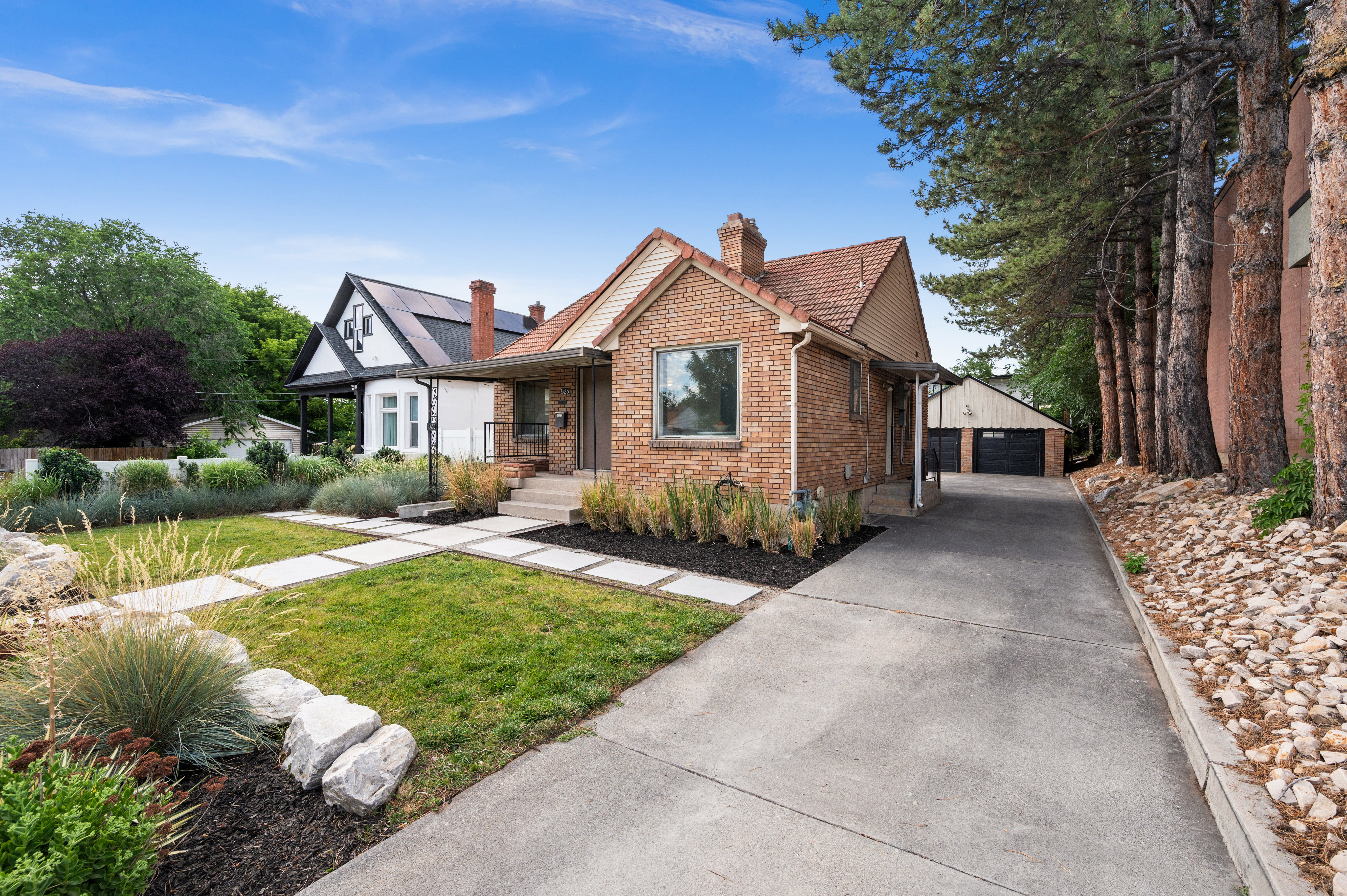 Brick facade residence featuring a tiled roof and a concrete driveway