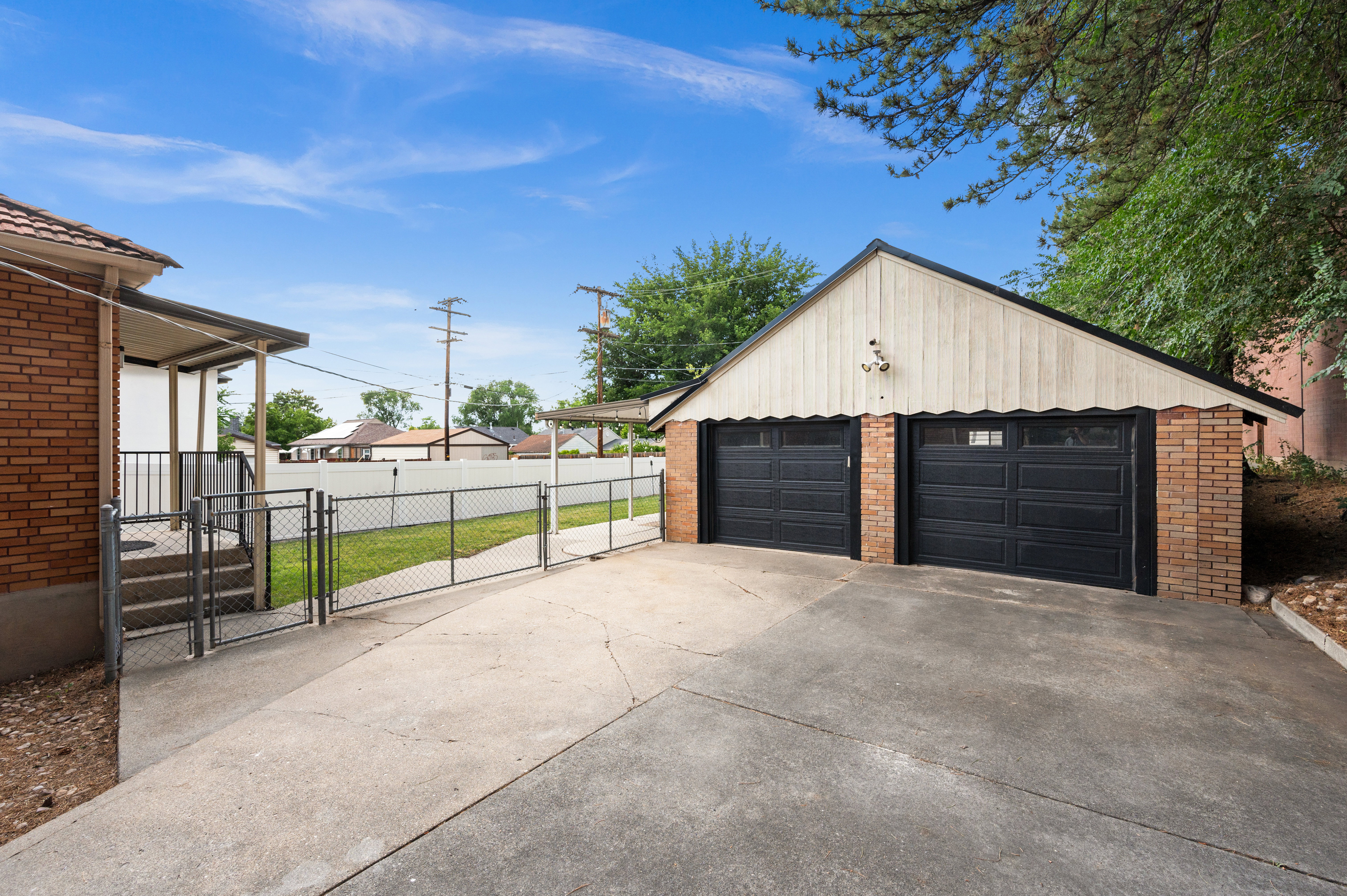 Two-car detached garage with brick columns and white vertical siding