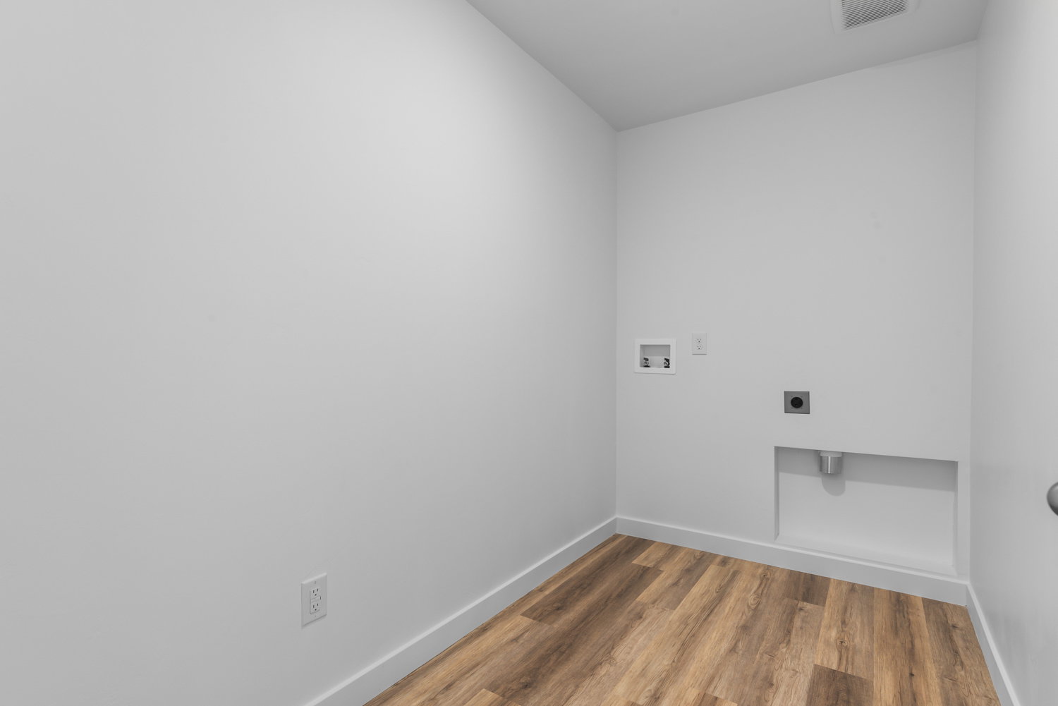 Dedicated utility room with wood-finish flooring and white baseboards