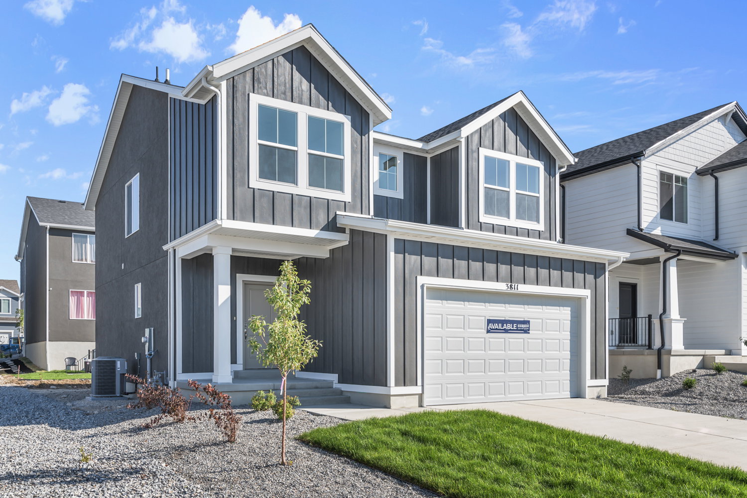 Modern two-story residence featuring dark vertical siding and white trim accents