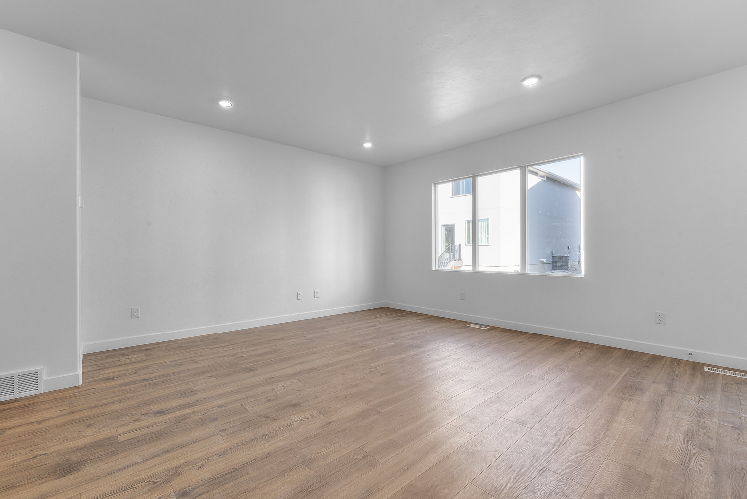 Open concept living space featuring wood-finish flooring and recessed lighting