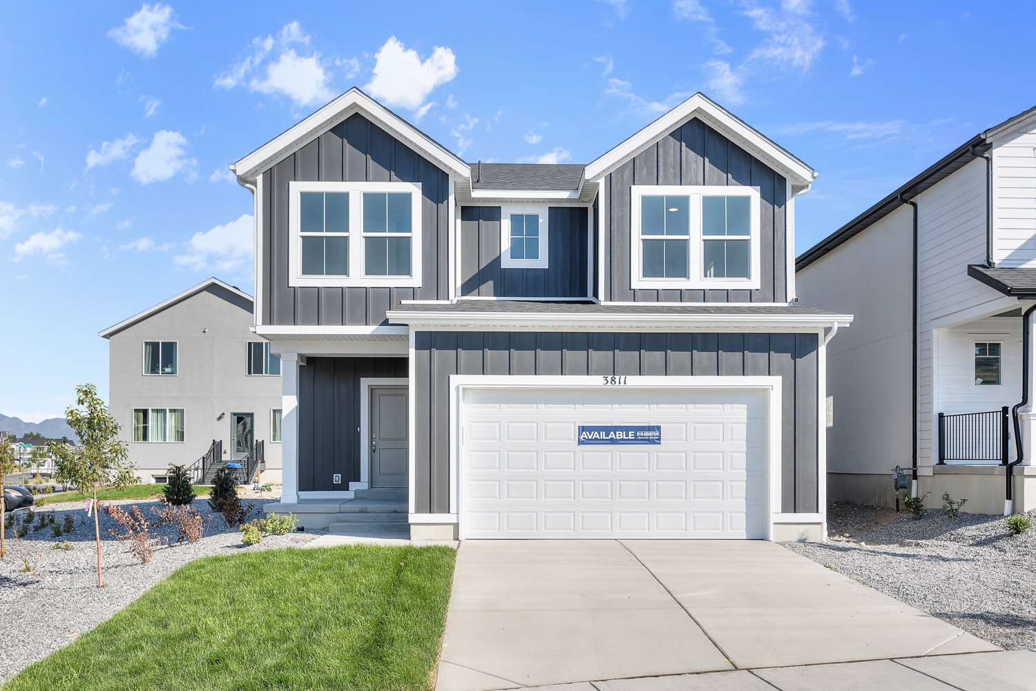 Modern two-story residence featuring dark vertical siding and white trim