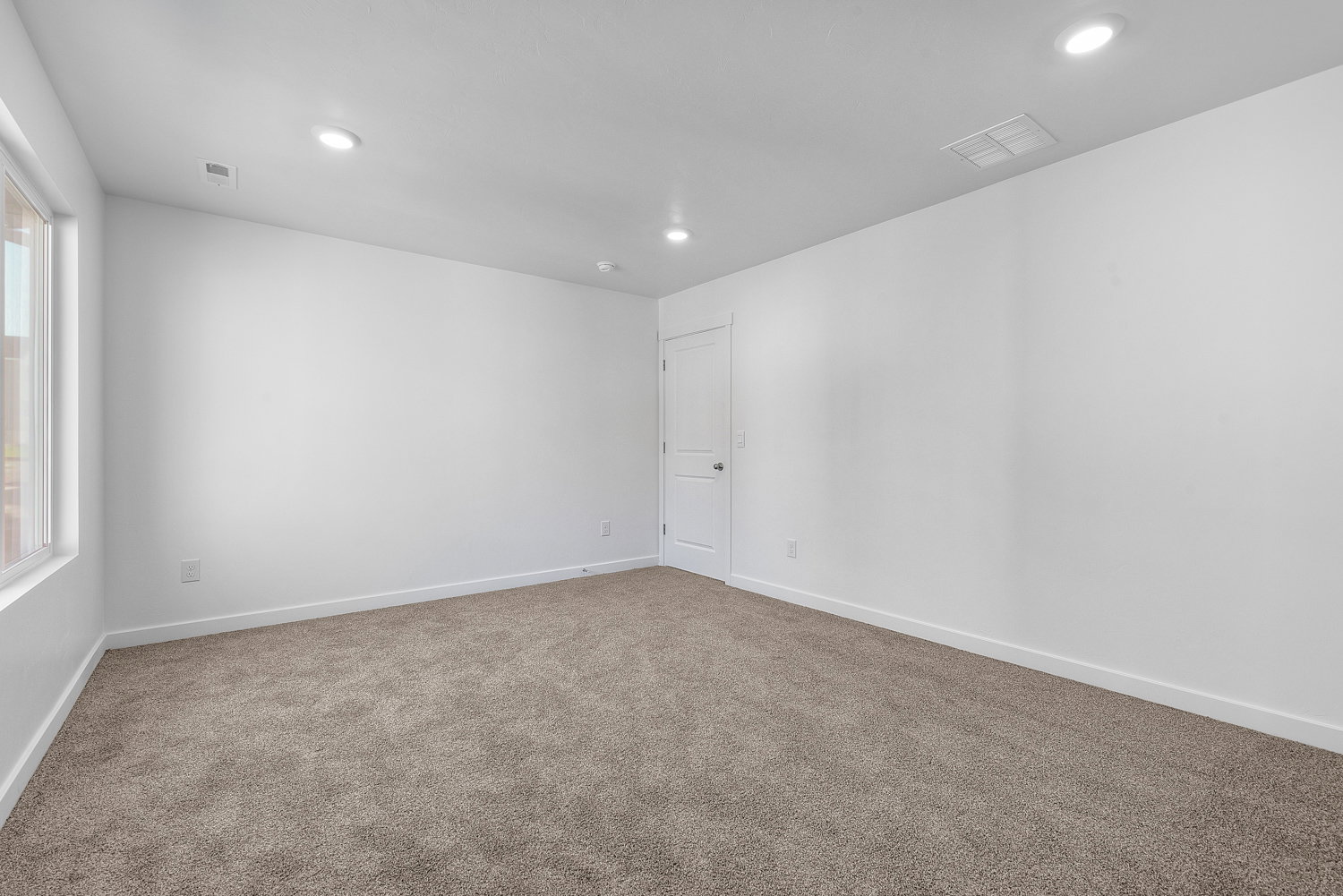 Expansive room featuring neutral-toned carpeting, white walls, and recessed lighting