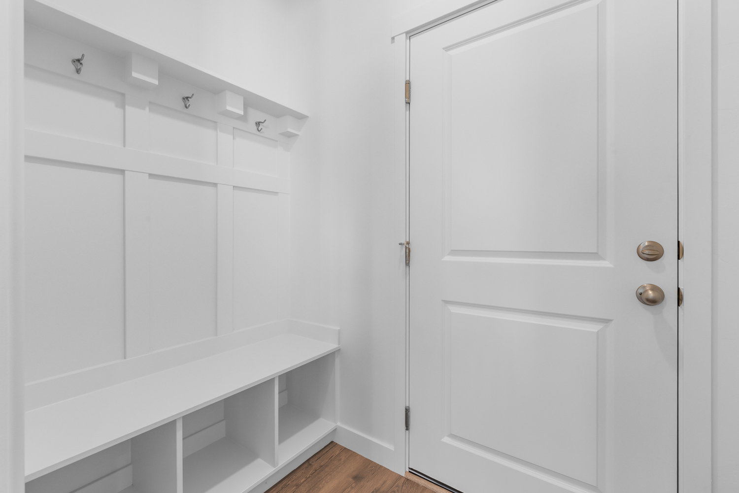 Entryway mudroom featuring a built-in bench with storage cubbies and wall-mounted coat hooks