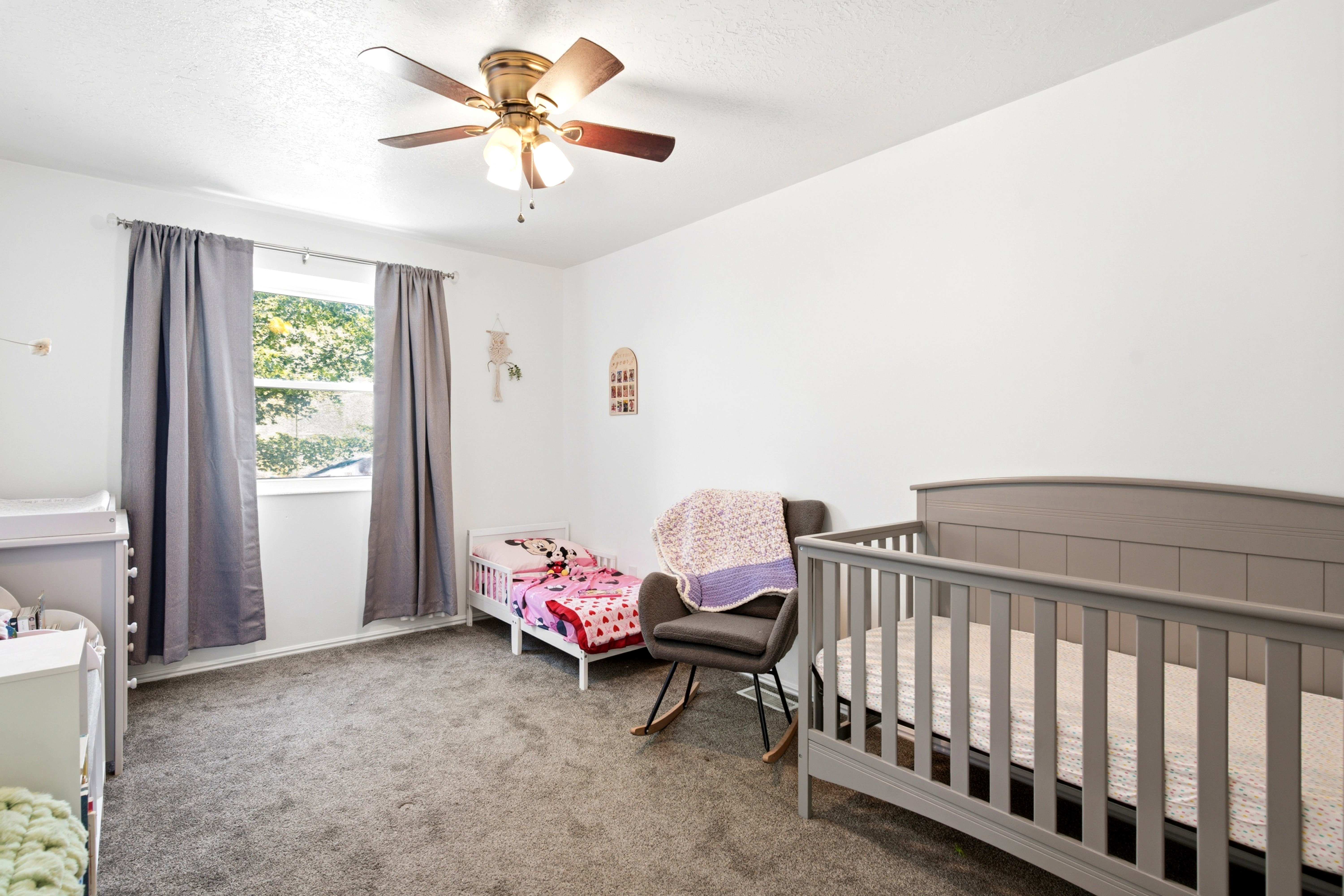 Carpeted room featuring a ceiling fan with integrated lighting, a double-hung window with a white frame, and light gray wall-to-wall carpeting