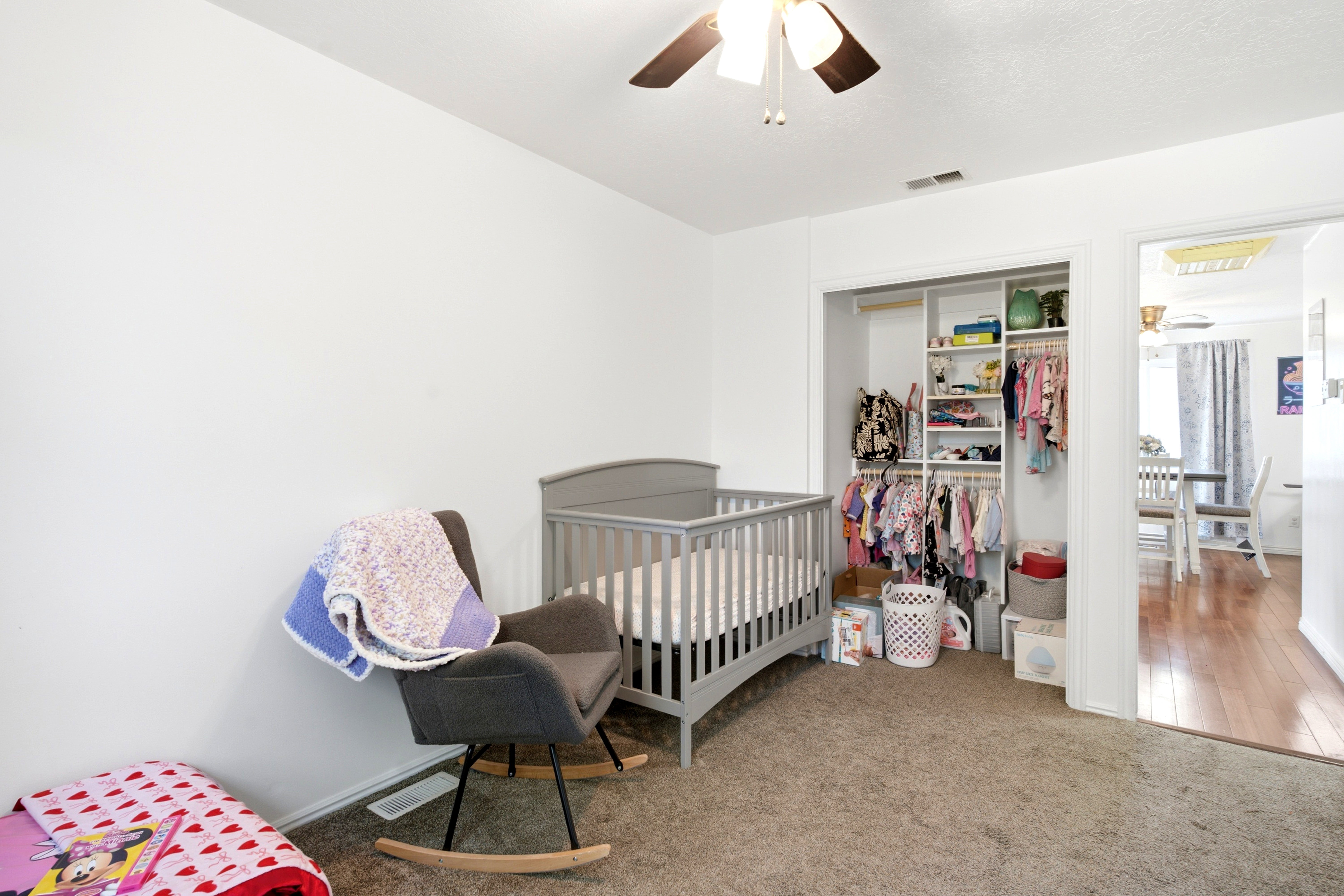Carpeted room featuring a built-in closet with shelving and hanging rods