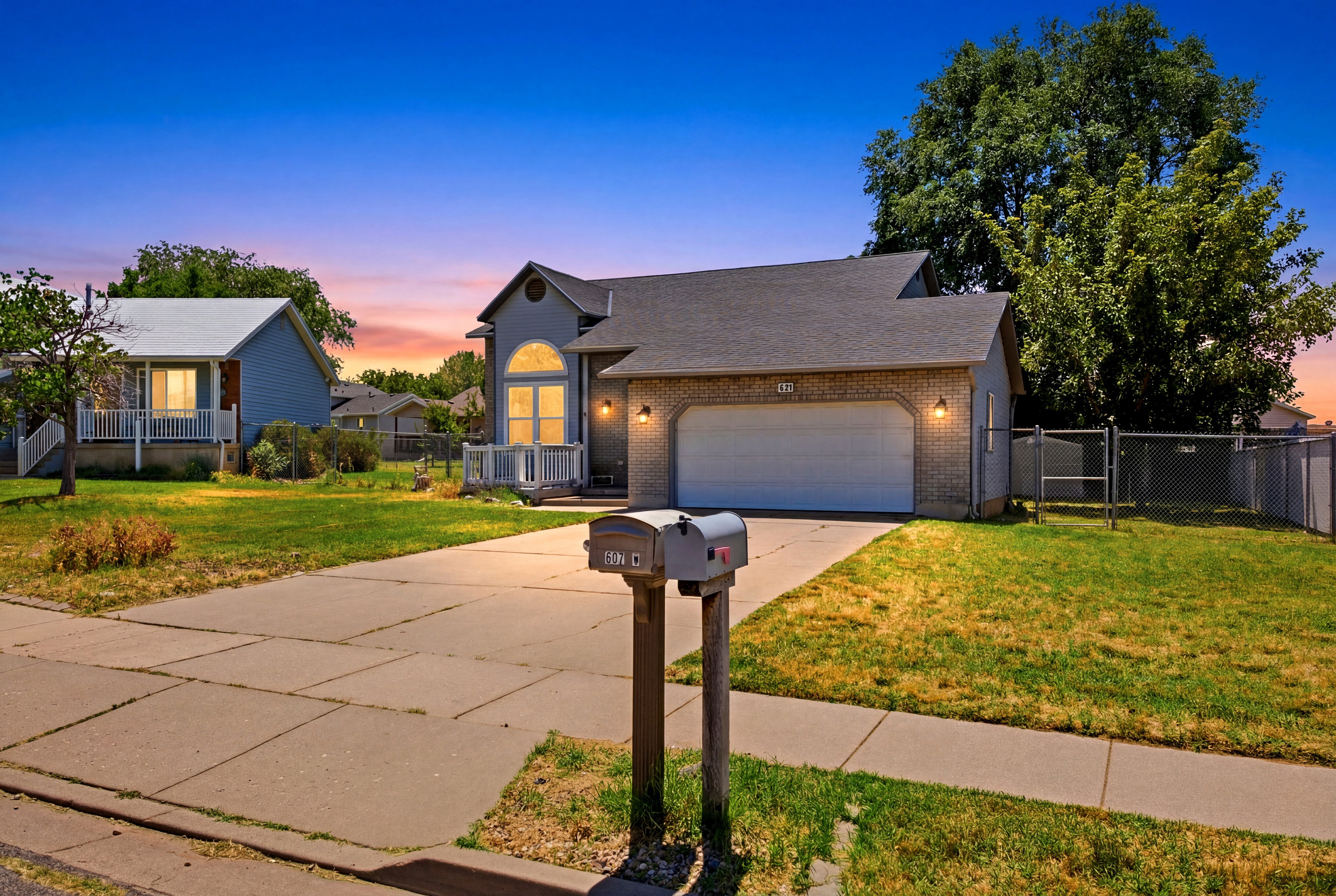 Brick-front exterior featuring a two-car garage, a concrete driveway, and an arched window design