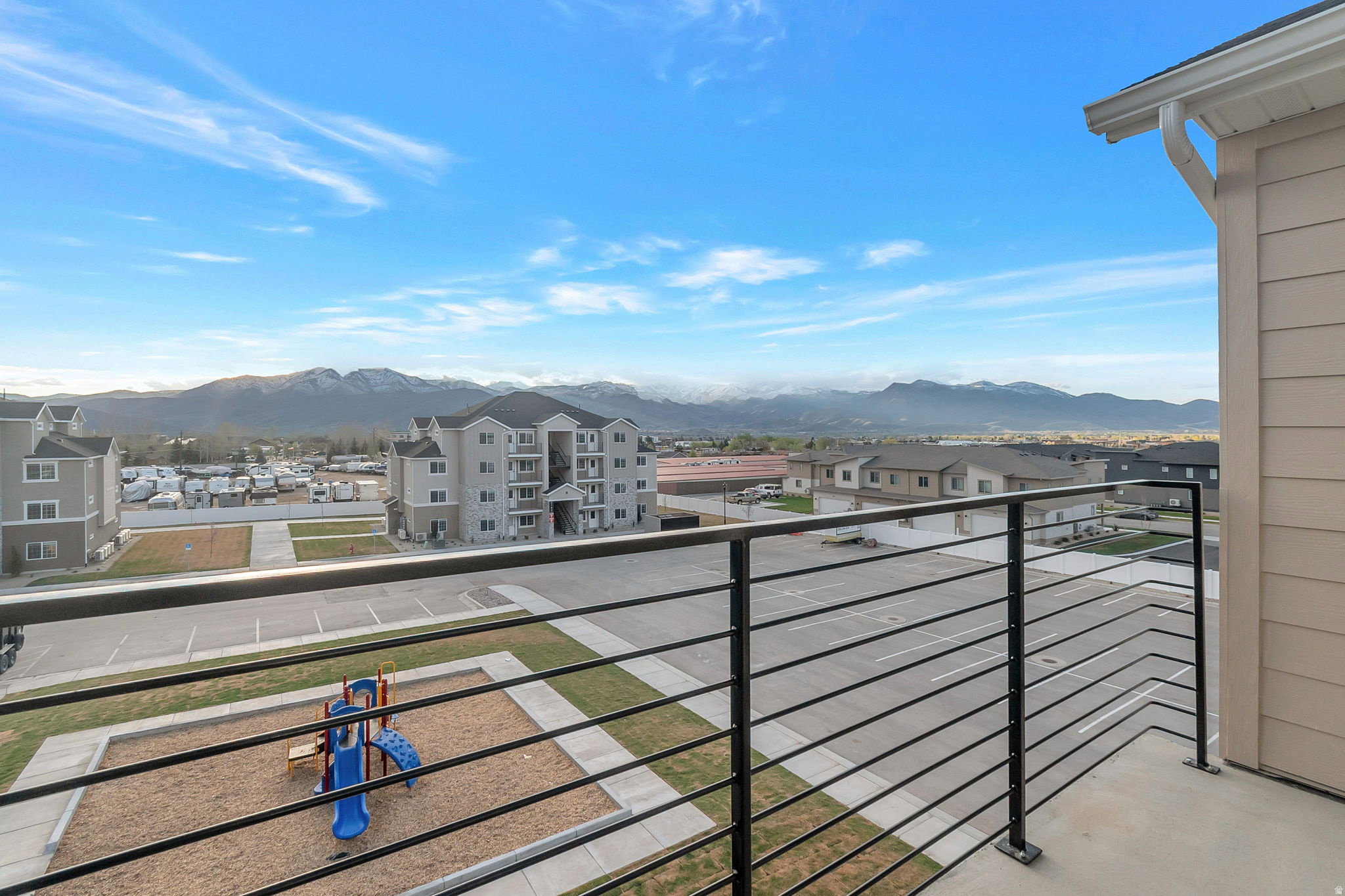 Balcony with horizontal metal railings and concrete flooring