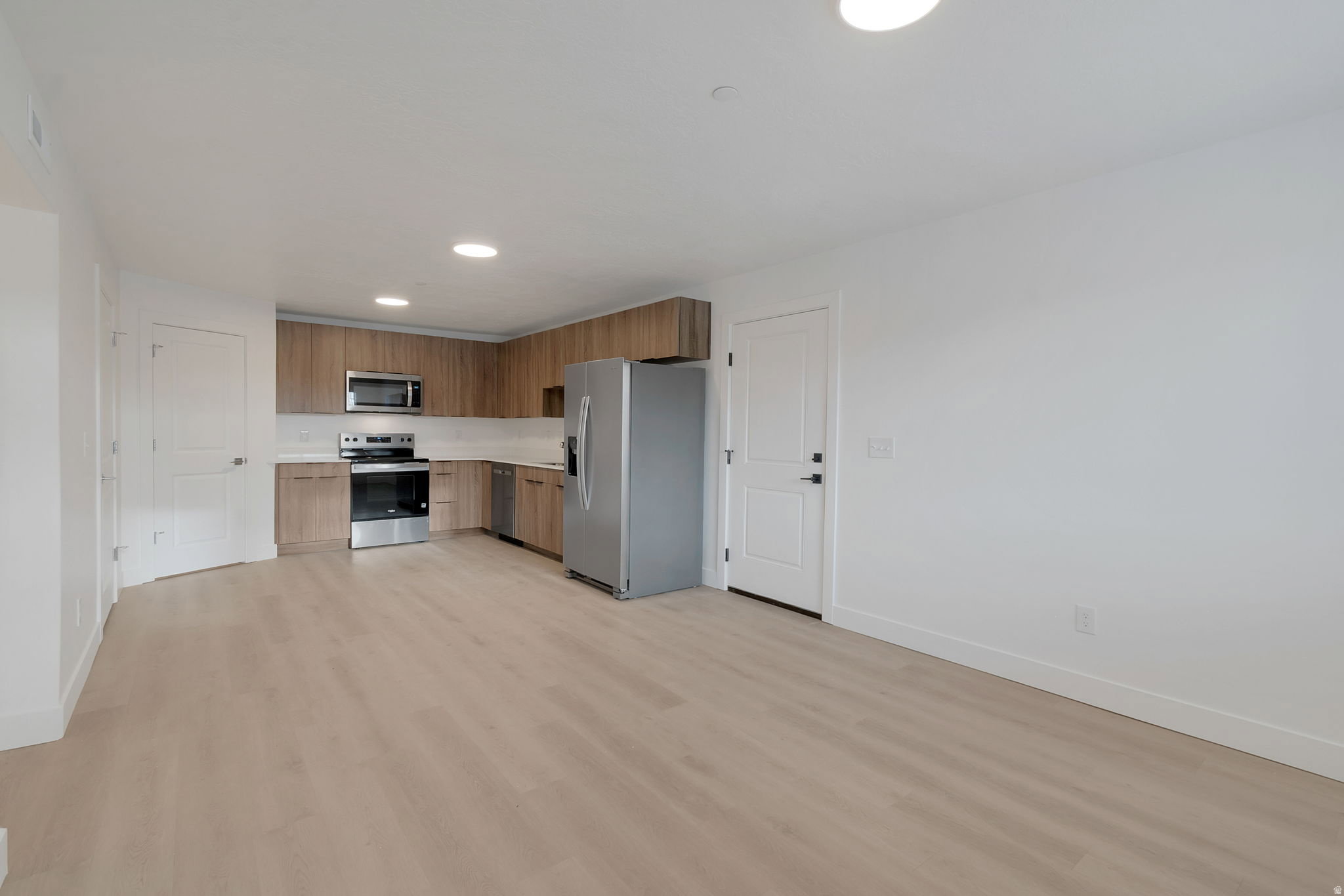 Open-concept living space with light wood-finish flooring