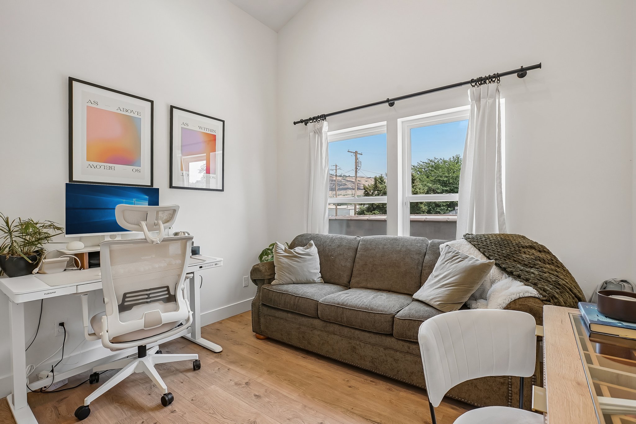High ceilings define this room, complemented by wood-finish flooring and white walls