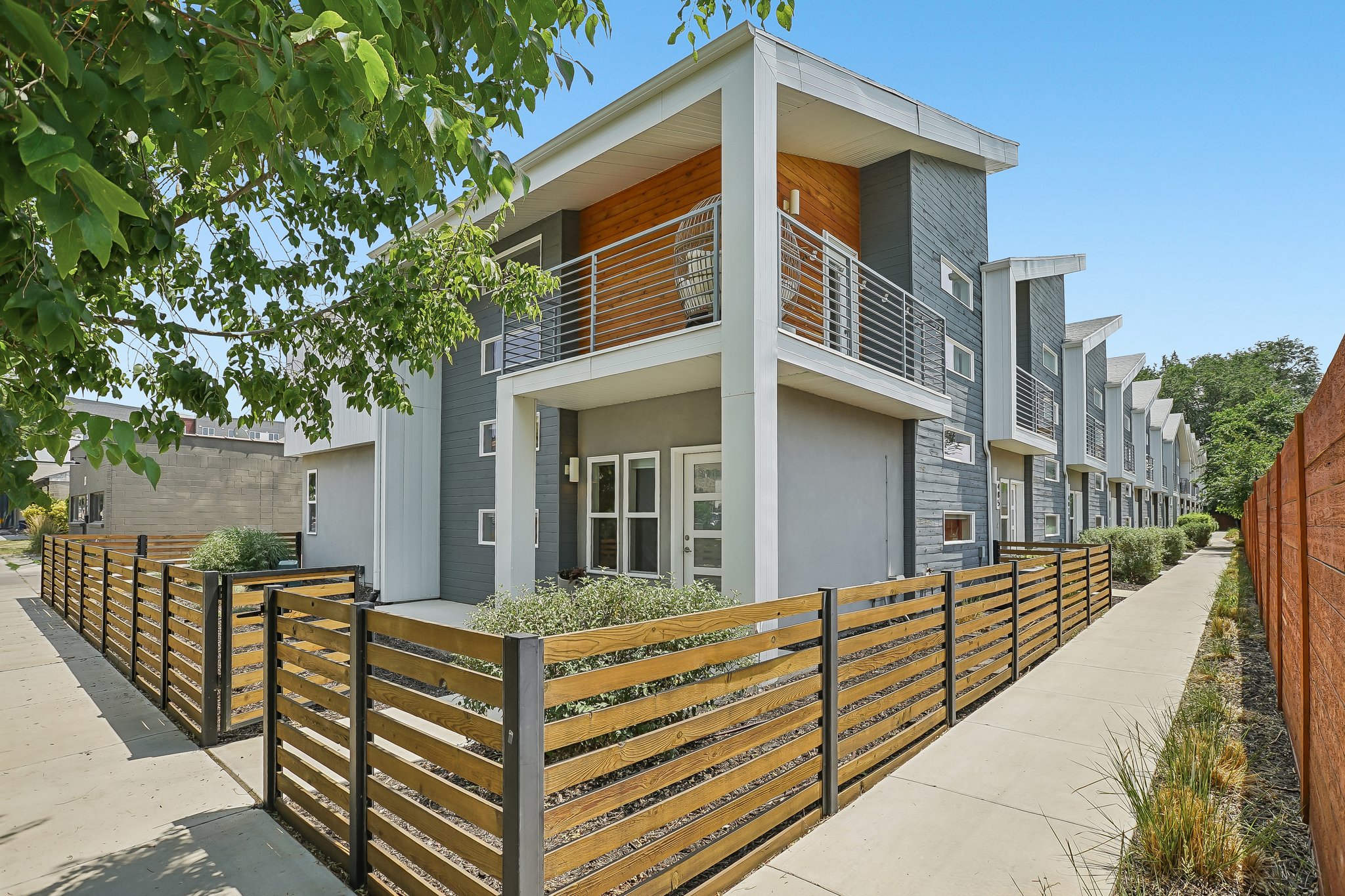 Contemporary multi-story exterior featuring a mix of gray siding and wood paneling