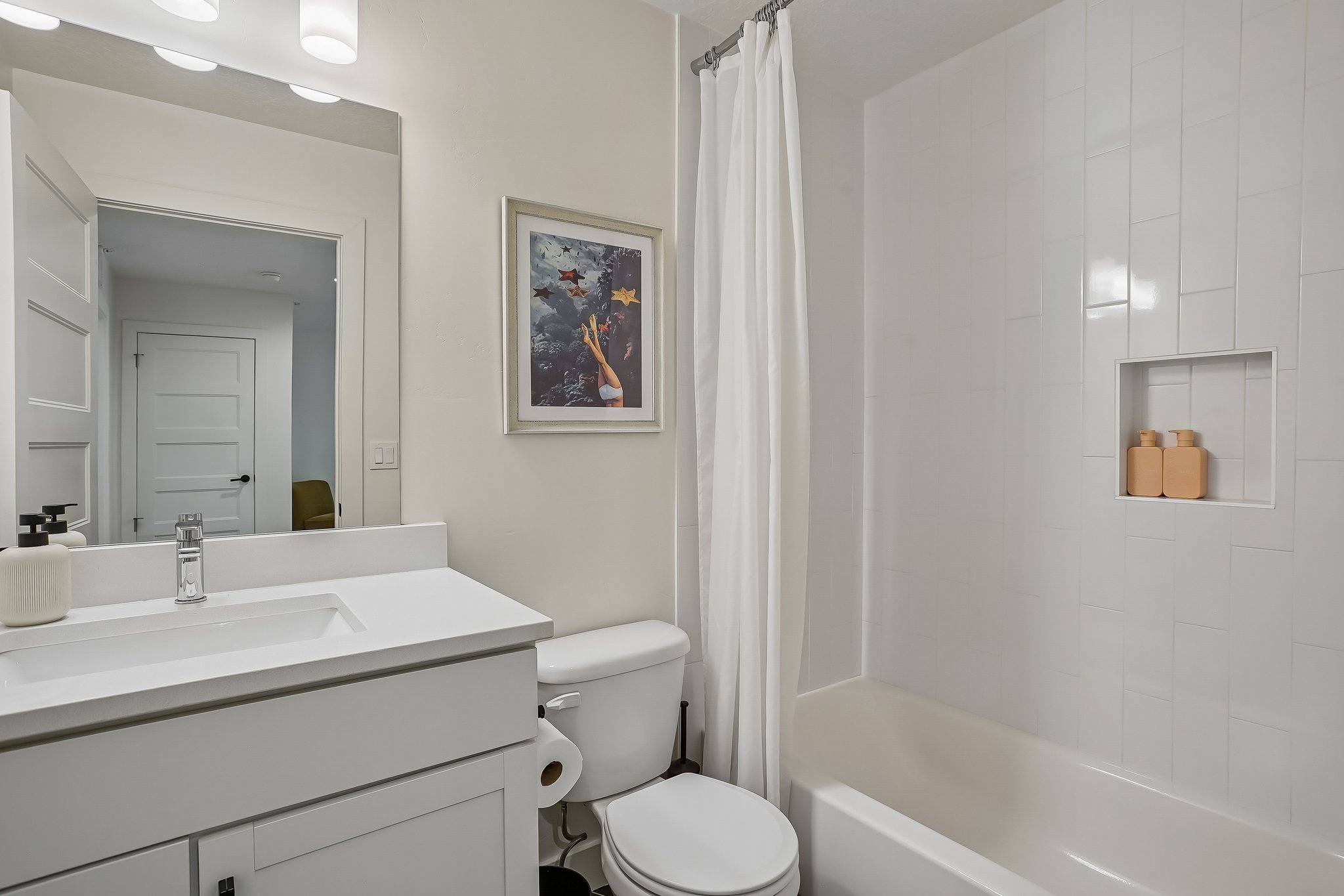 Contemporary bathroom featuring a vanity with an integrated sink, polished chrome faucet, and white countertop