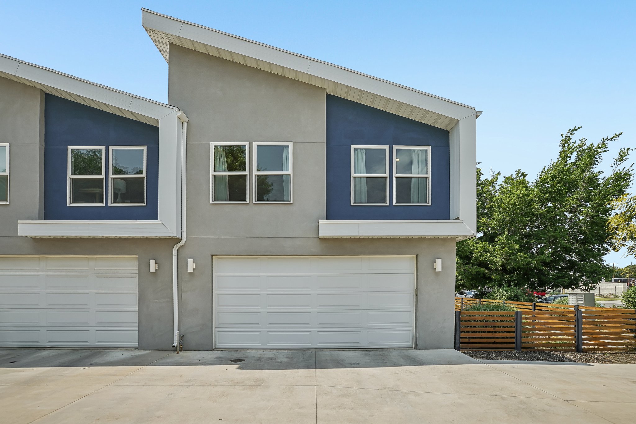 Contemporary exterior with a distinctive angled roofline and contrasting blue accent paneling