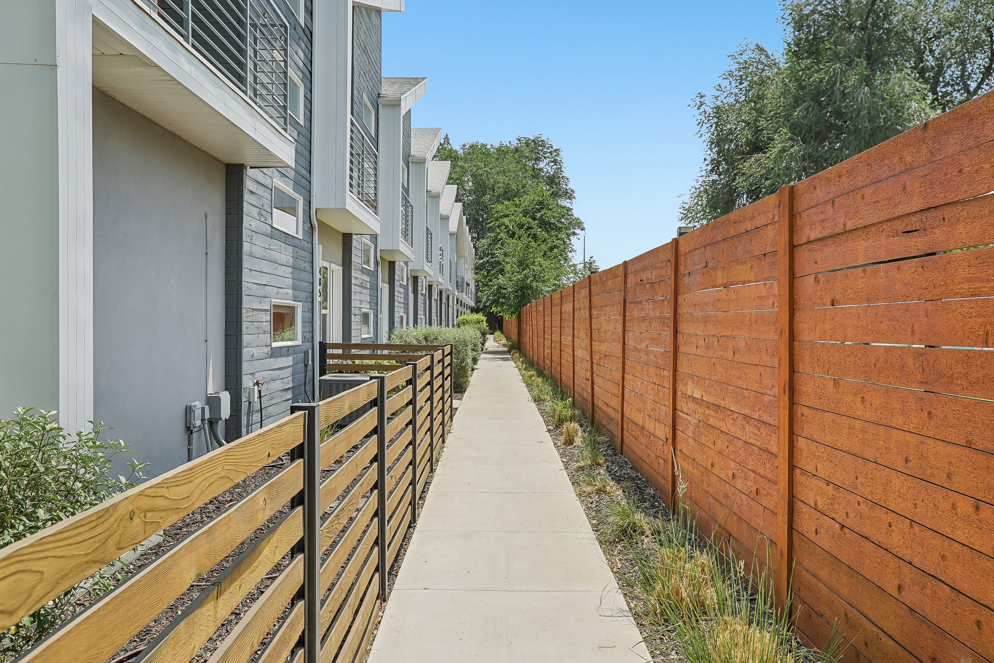 Modern row of townhomes featuring gray and white exteriors with horizontal siding