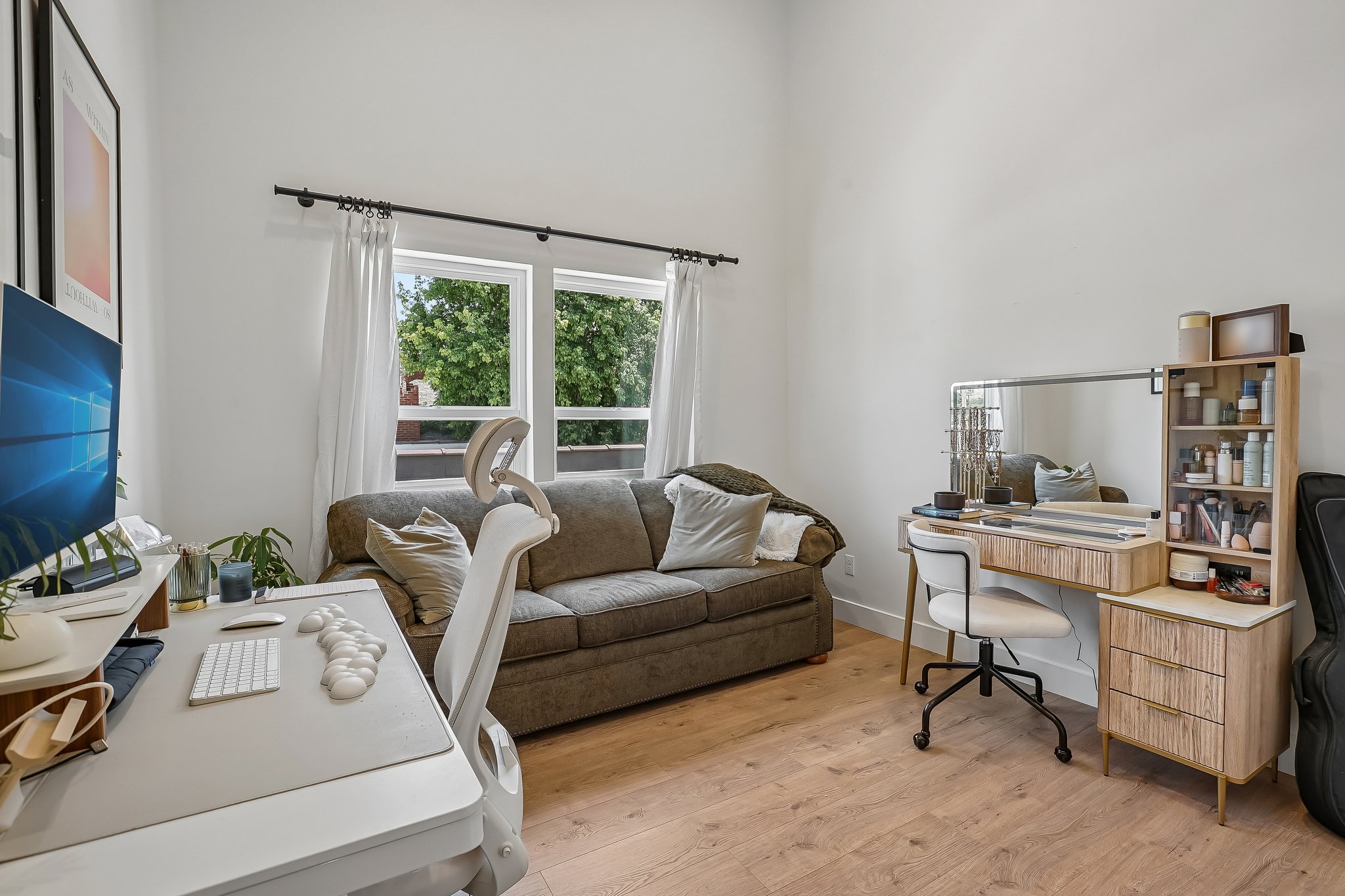 Spacious room featuring light wood-finish flooring, high ceilings, and ample natural light from multiple windows