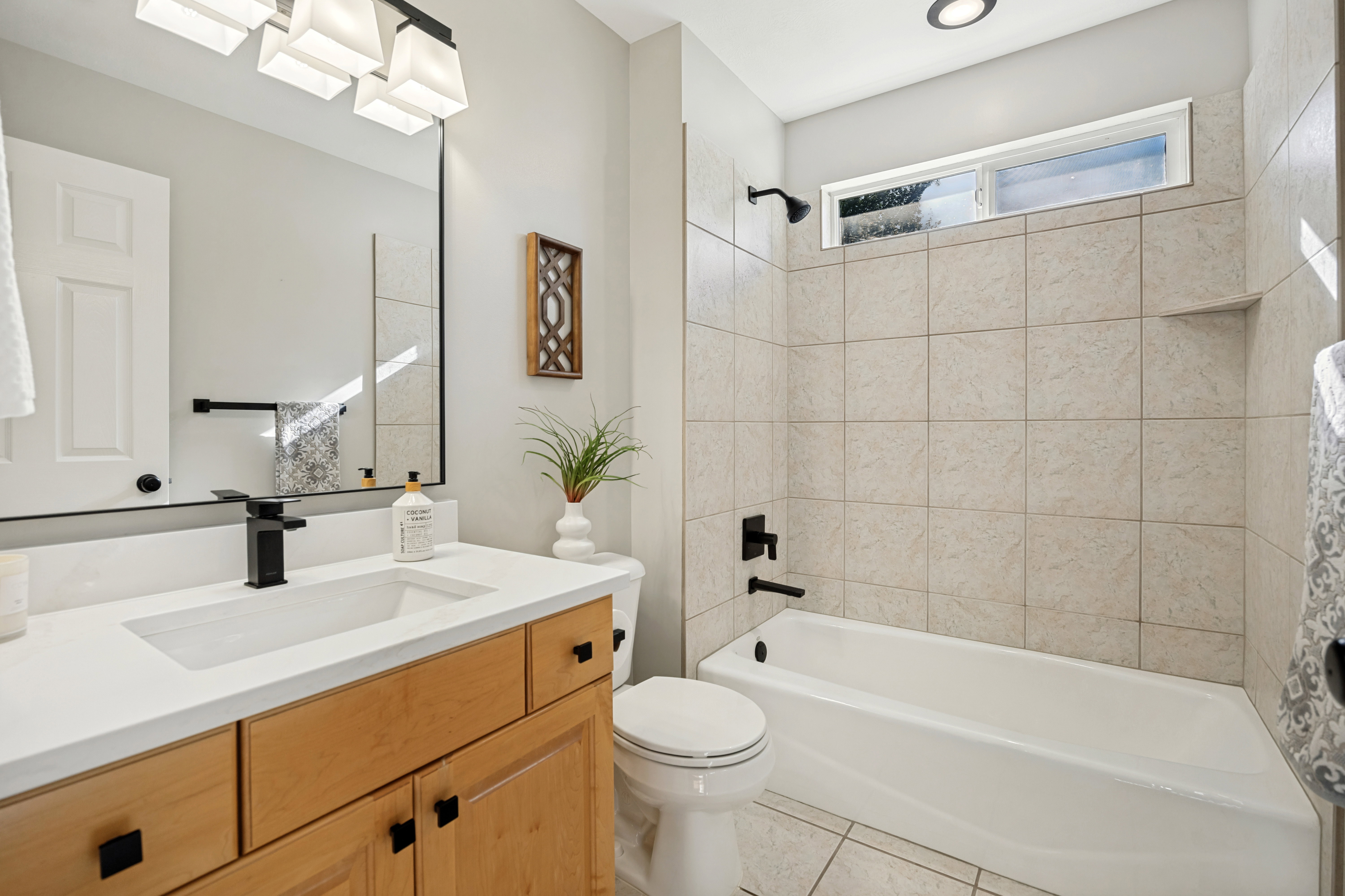 Full Bathroom featuring a light wood-finish vanity with a white quarts countertop and integrated sink
