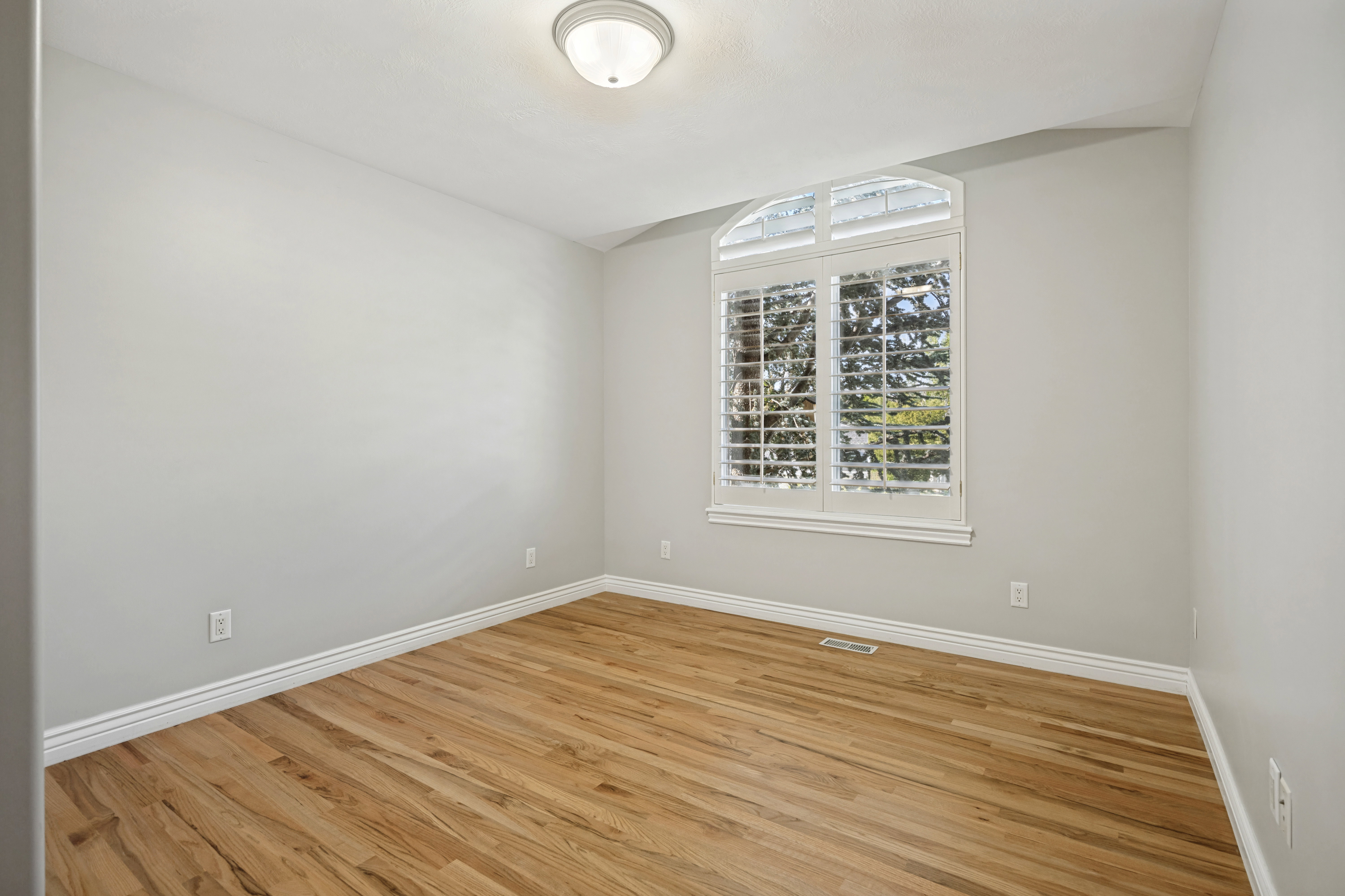 3rd Bedroom featuring wood flooring, light gray wall paint, and white baseboards