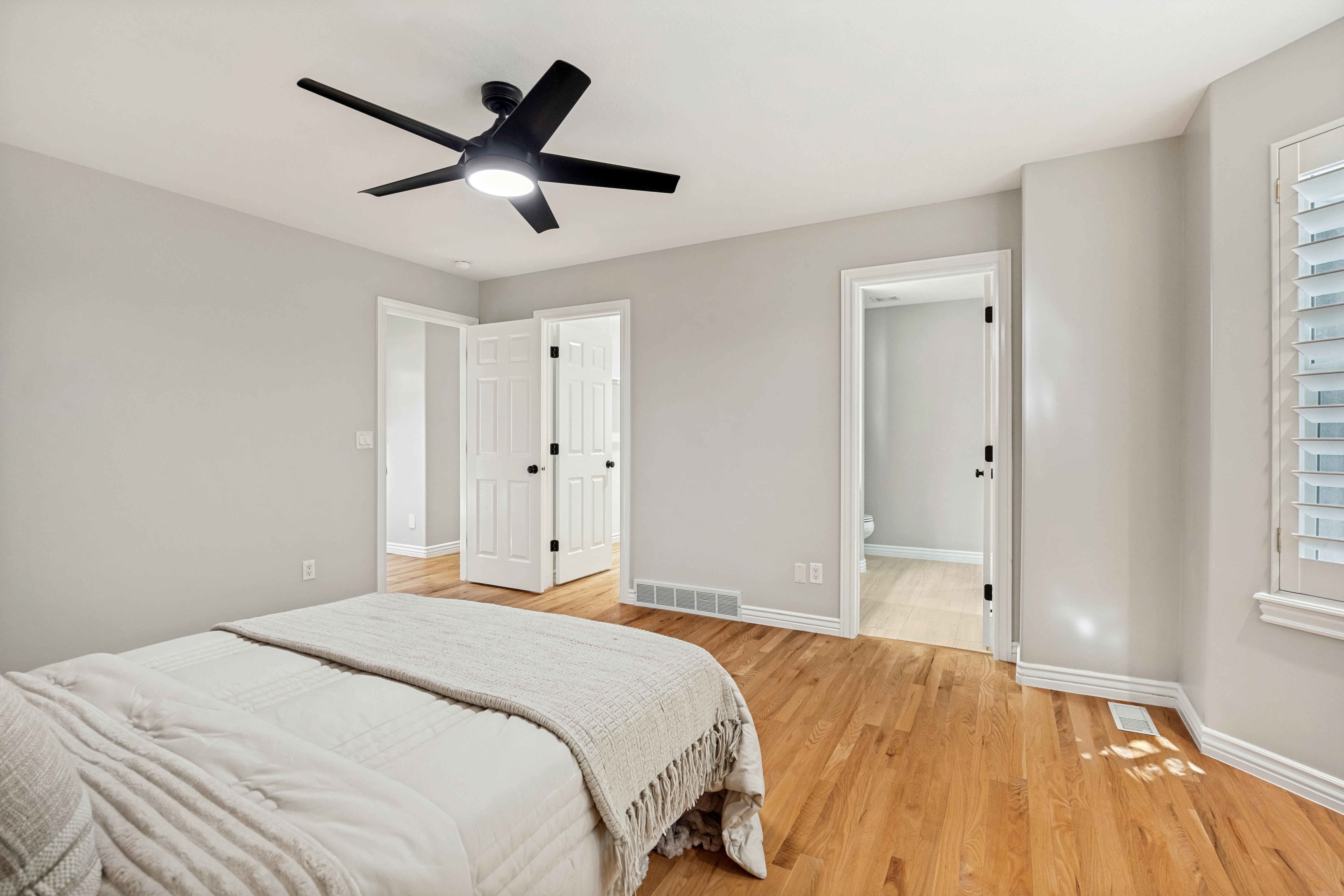 Primary Bedroom featuring hardwood flooring that extends throughout this room, complemented by light-toned walls and white trim. Walk in closet.