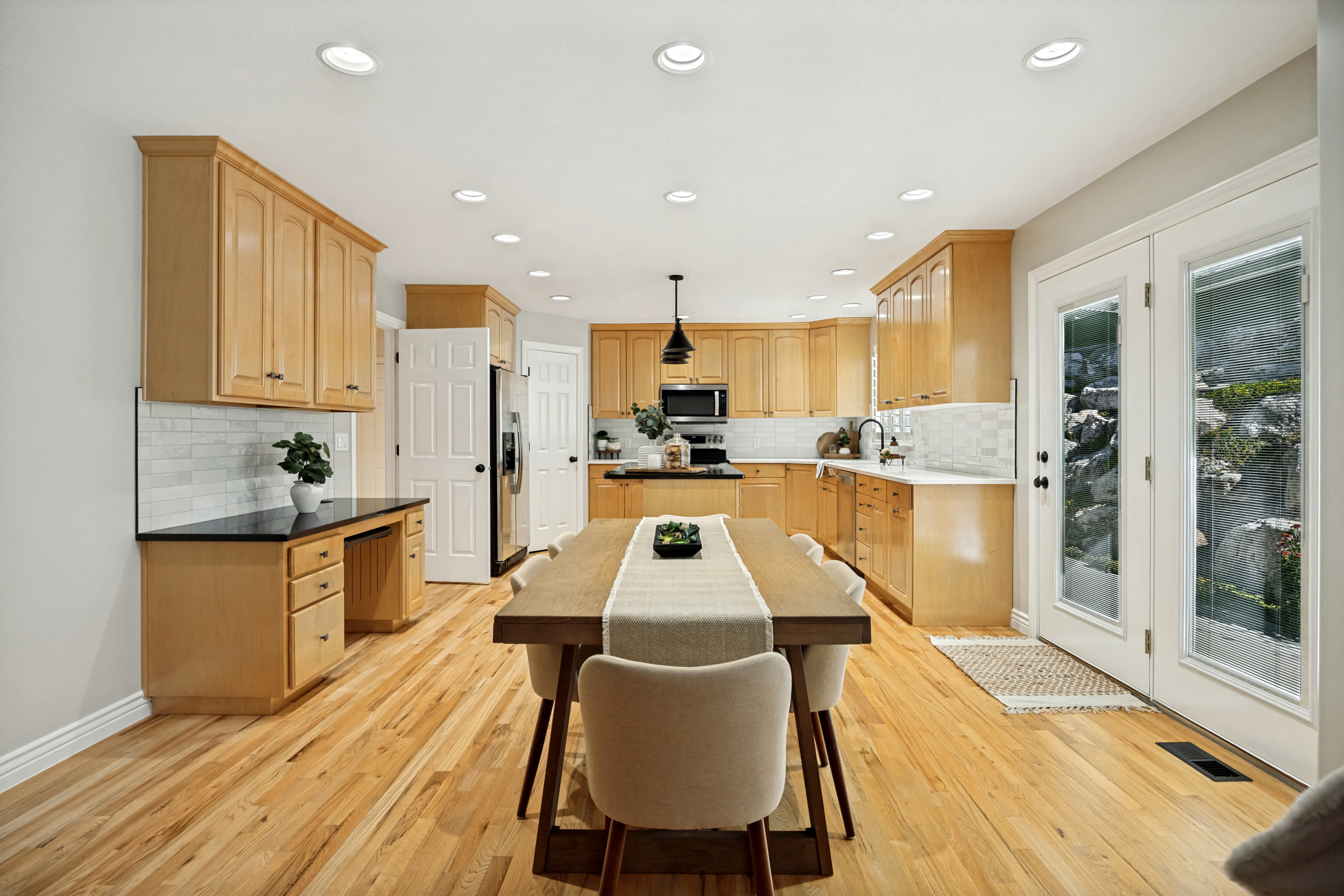 Open-concept kitchen featuring real wood cabinetry and a functional built-in desk area