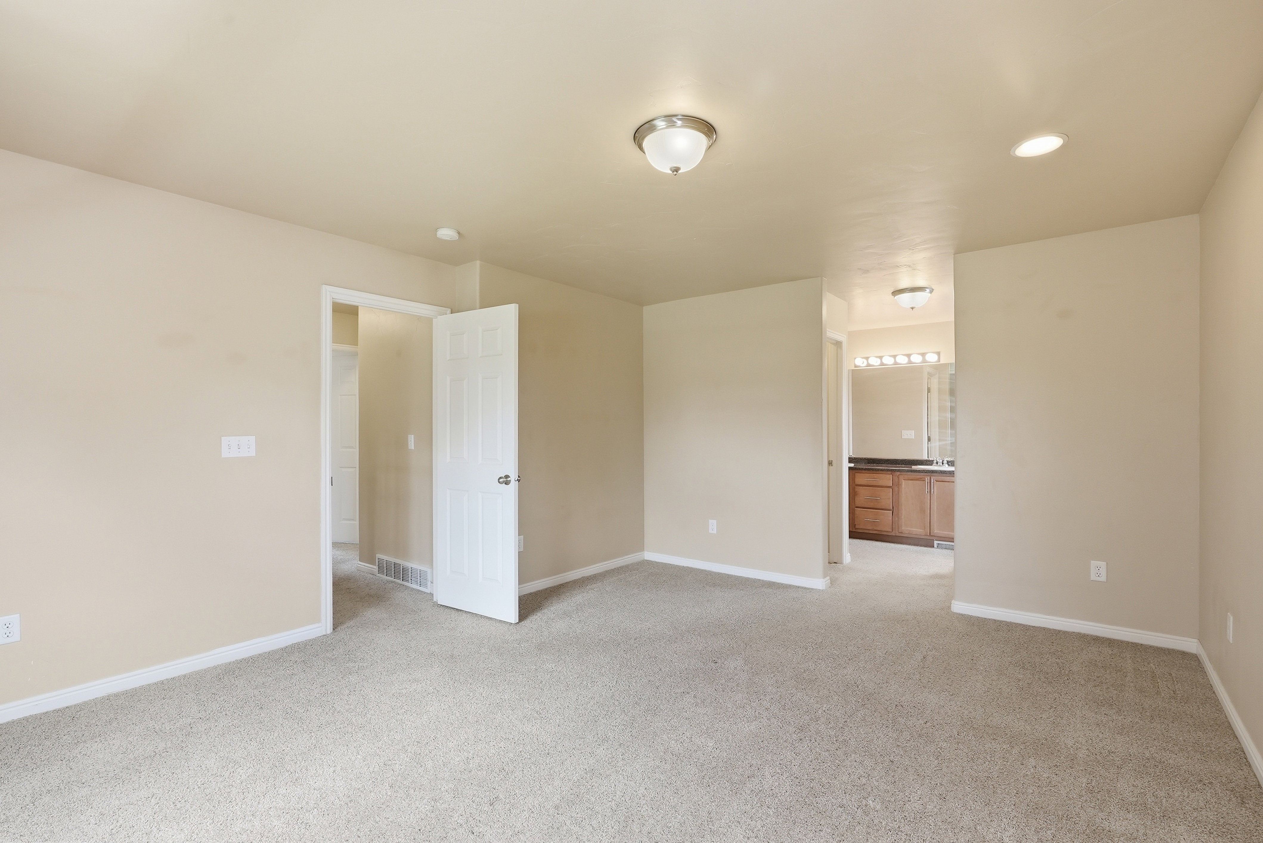 Spacious room featuring neutral carpeting and light-toned wall paint