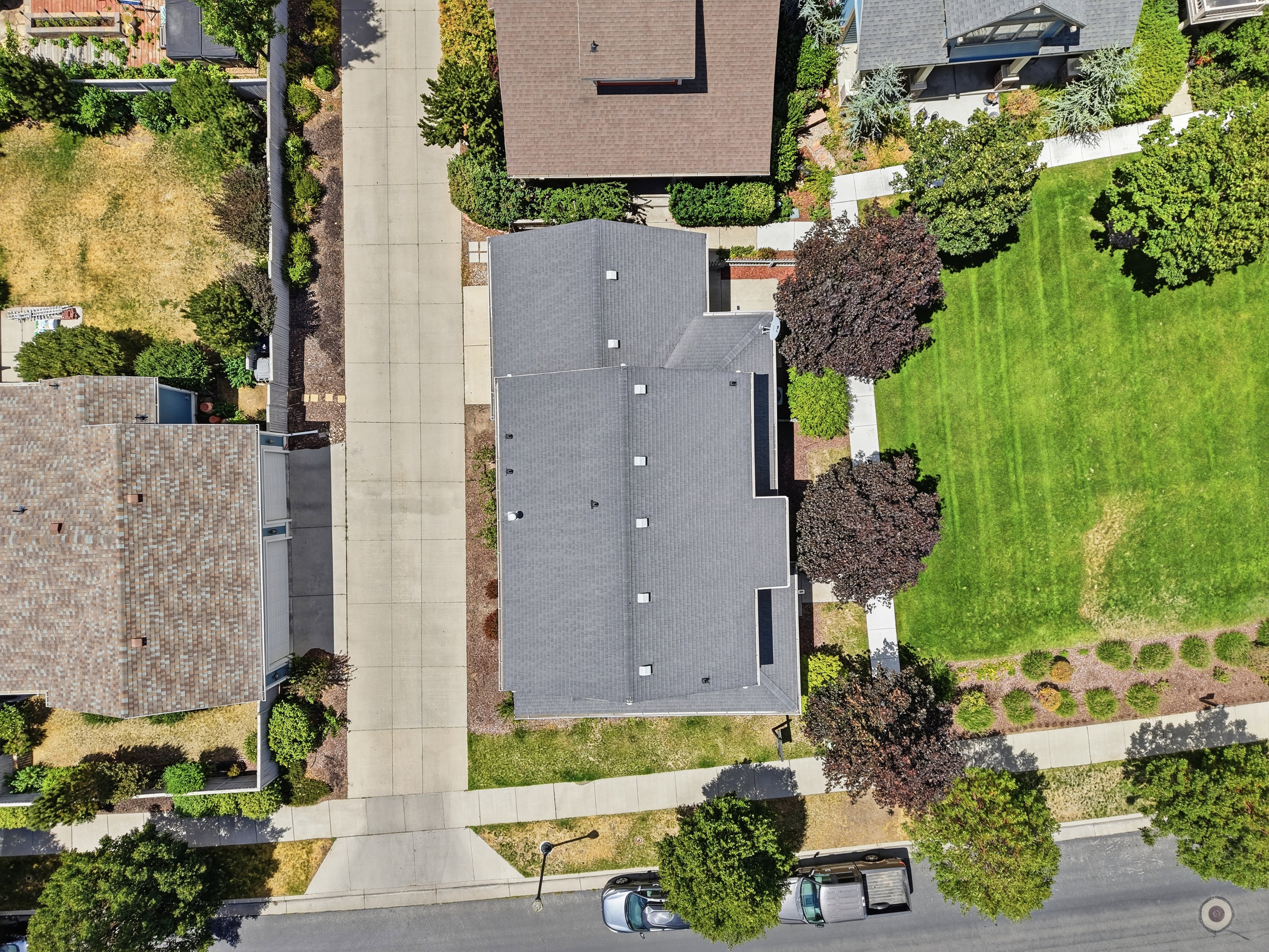 Property with a dark shingle roof and a paved driveway