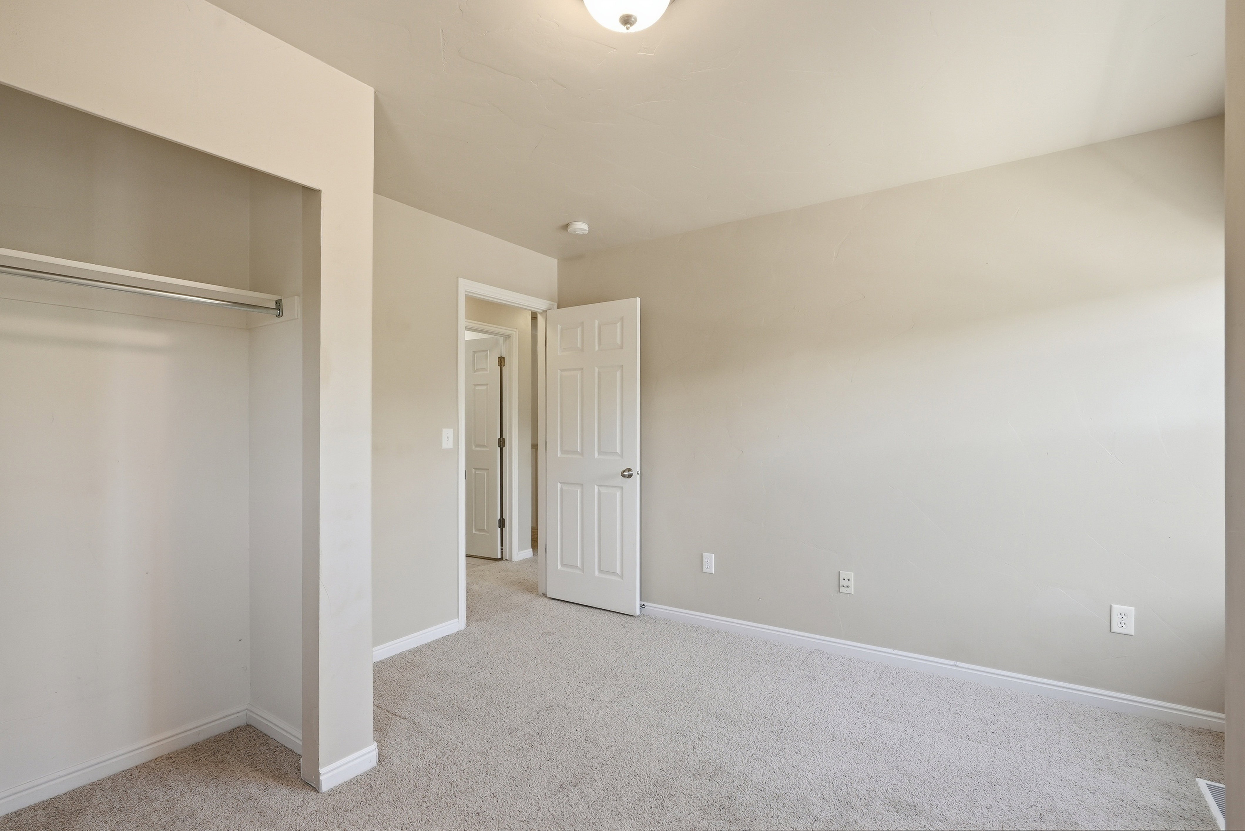 Neutral-toned carpet flooring with light wall paint and white trim molding