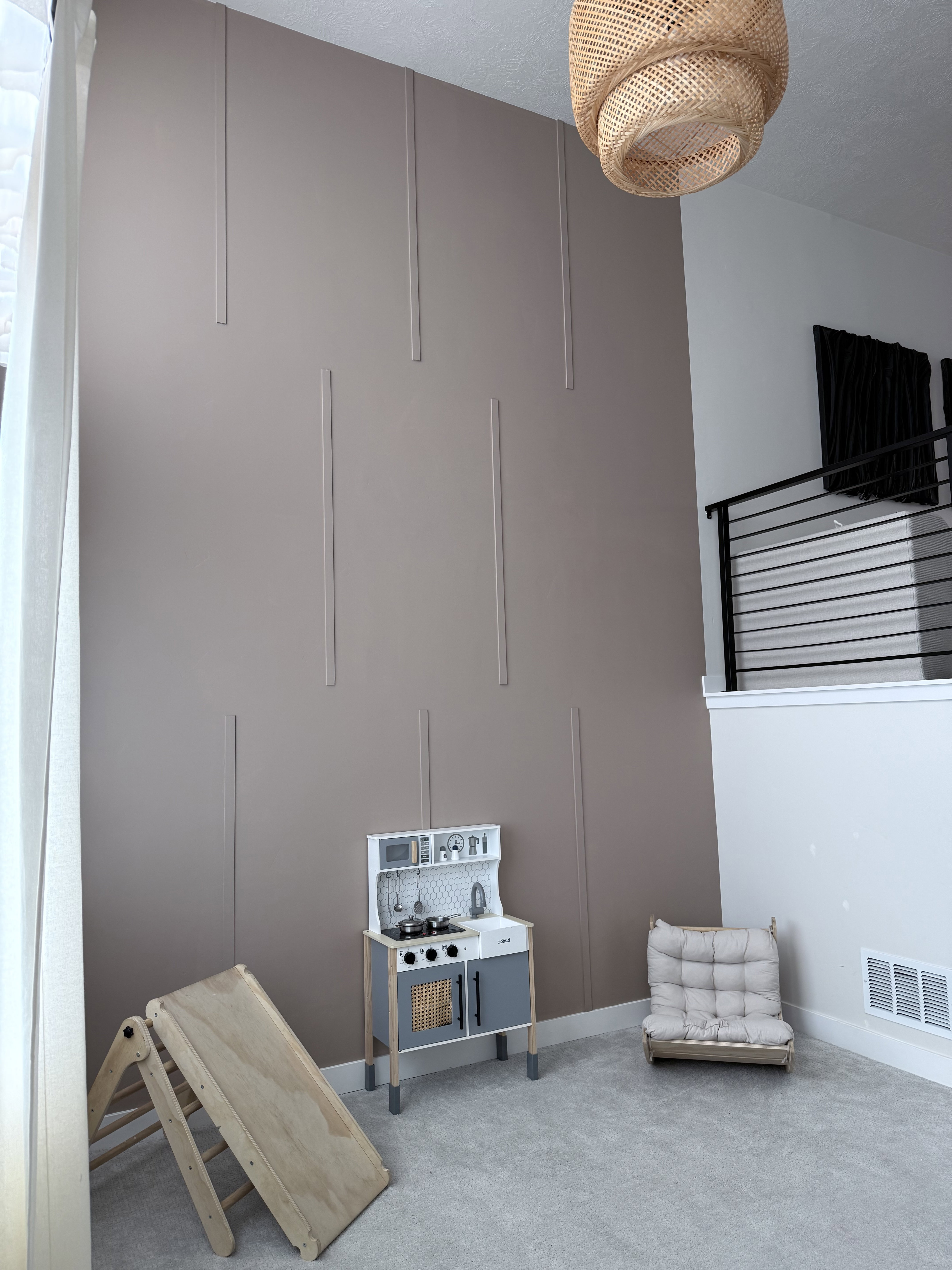 Two-story accent wall with vertical paneling, textured ceiling, and recessed lighting