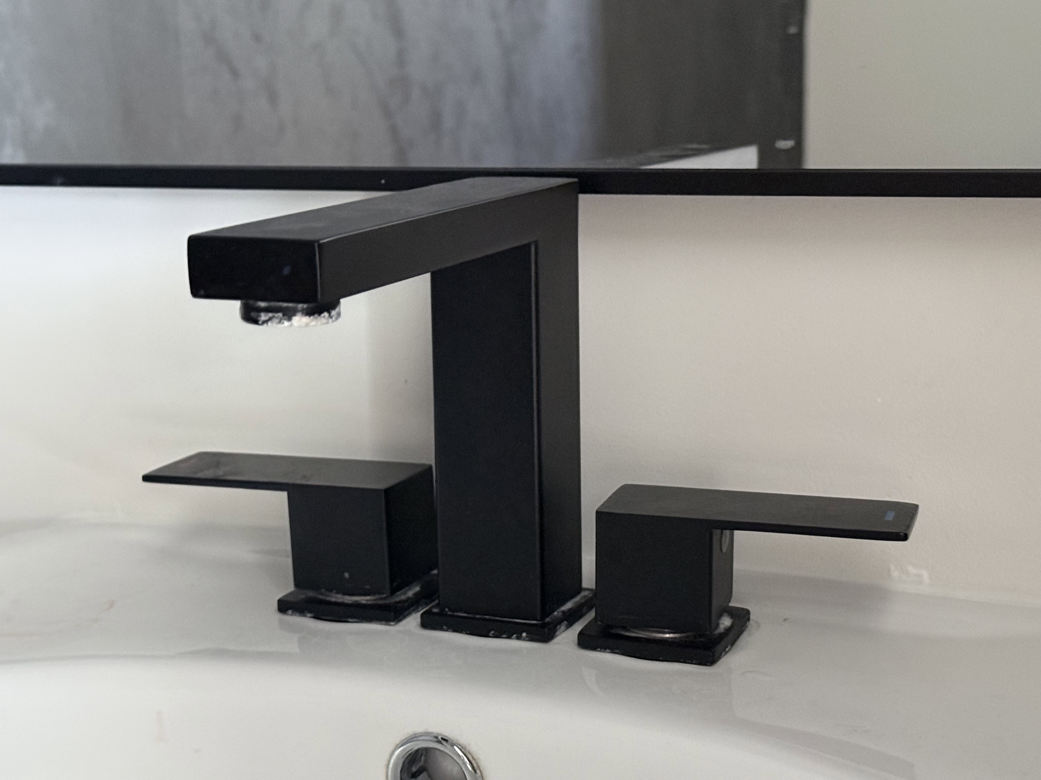 Modern matte black three-piece faucet set featuring a rectangular spout and lever handles
