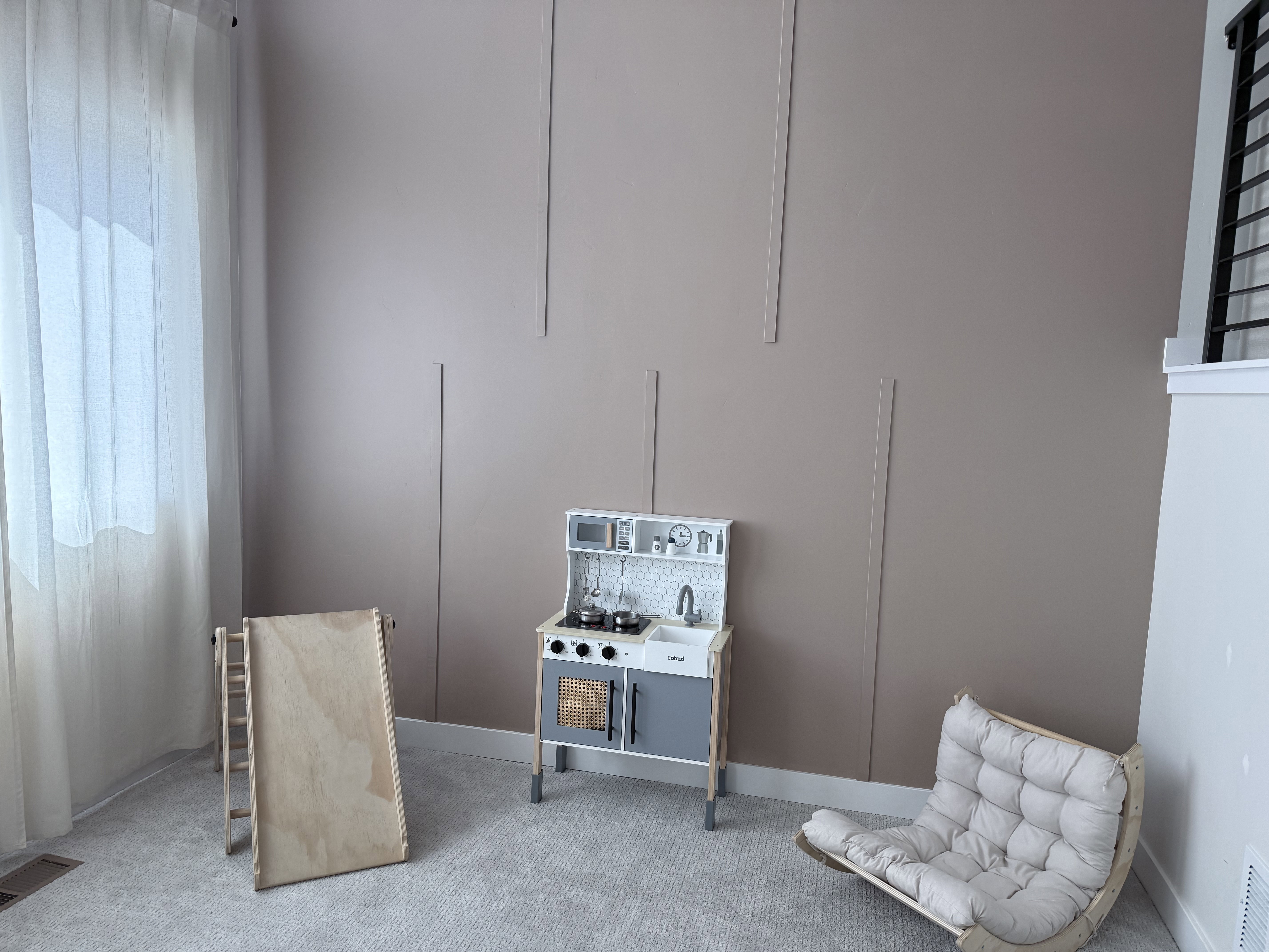 Wall paneling detail in a neutral tone with light-colored carpeting
