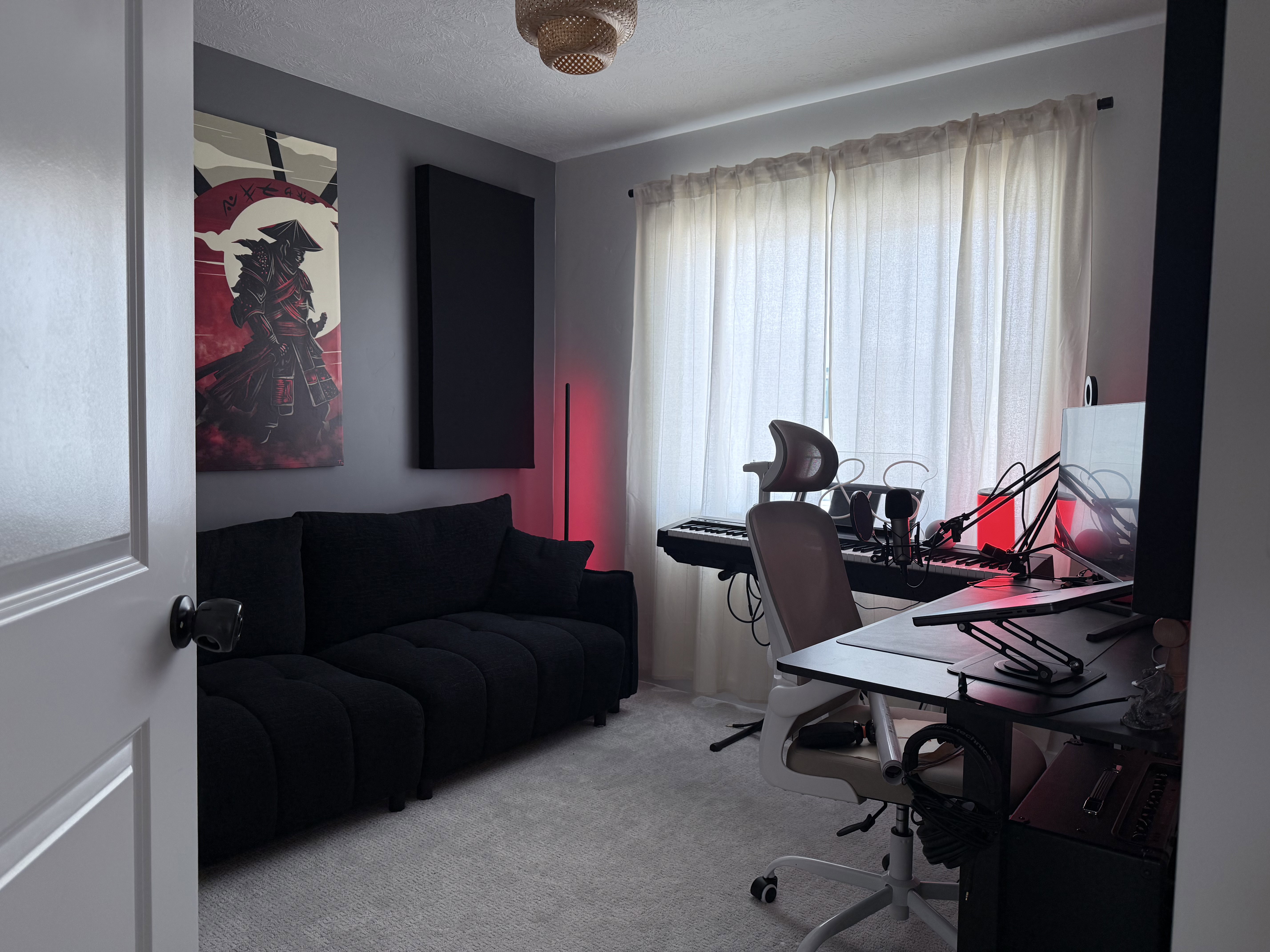 Carpeted room with a large window featuring sheer curtains