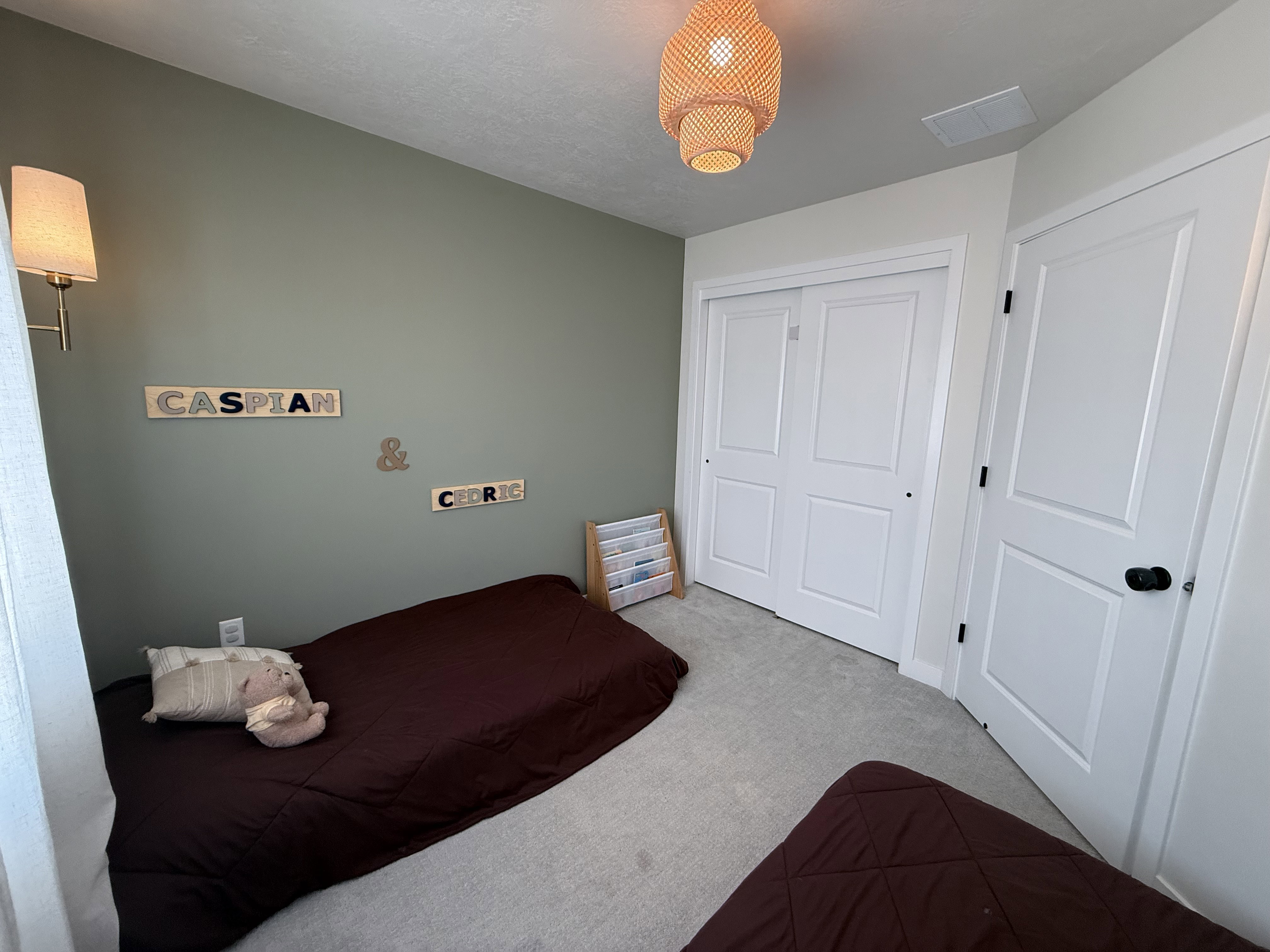 Wall-mounted sconce lighting illuminates a room with light green painted walls