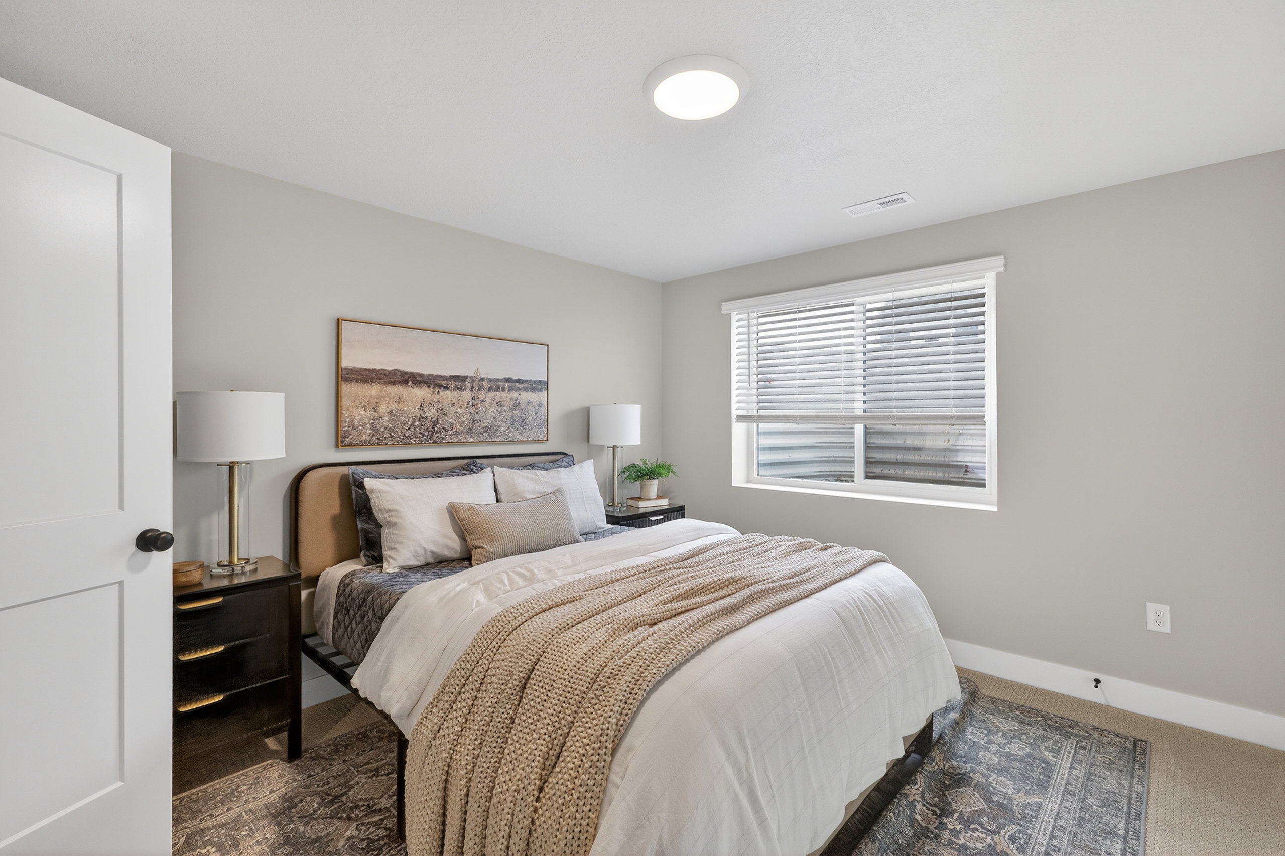Bedroom featuring light neutral wall paint, a single window with horizontal blinds, and a flush-mount ceiling light fixture