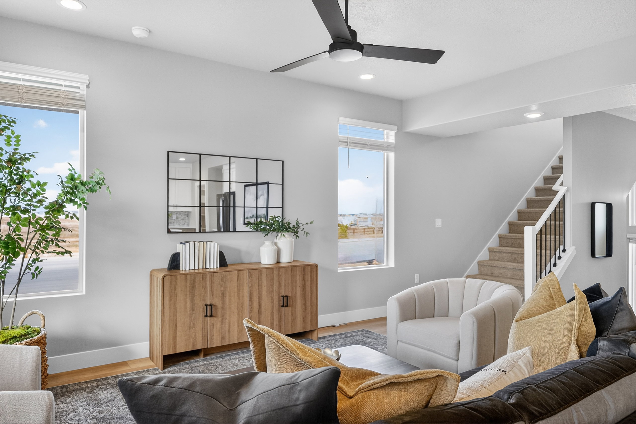 Open-concept living space featuring light-toned walls, recessed lighting, and wood-finish flooring