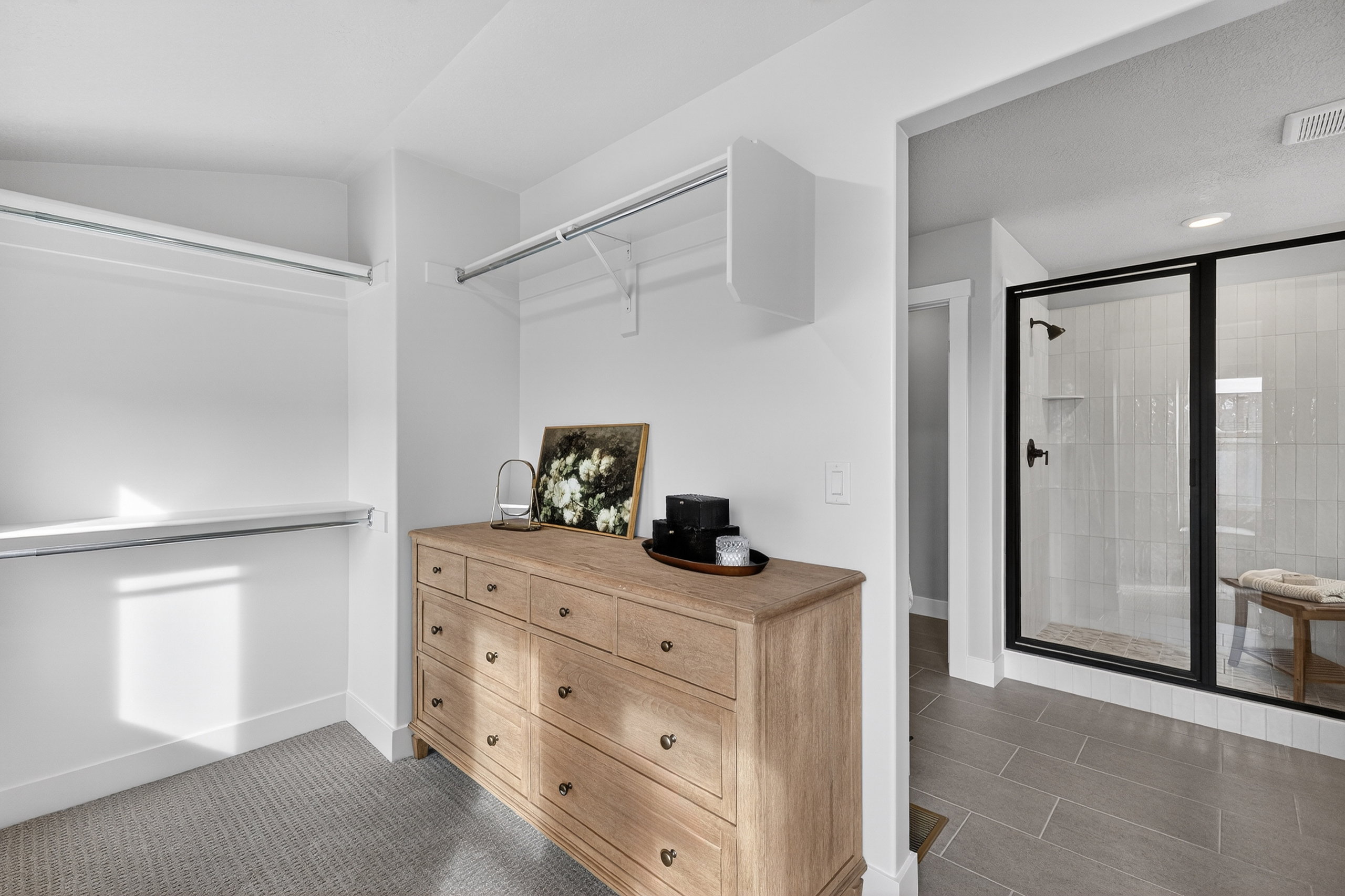 Spacious closet featuring carpet flooring, built-in shelving, and hanging rods