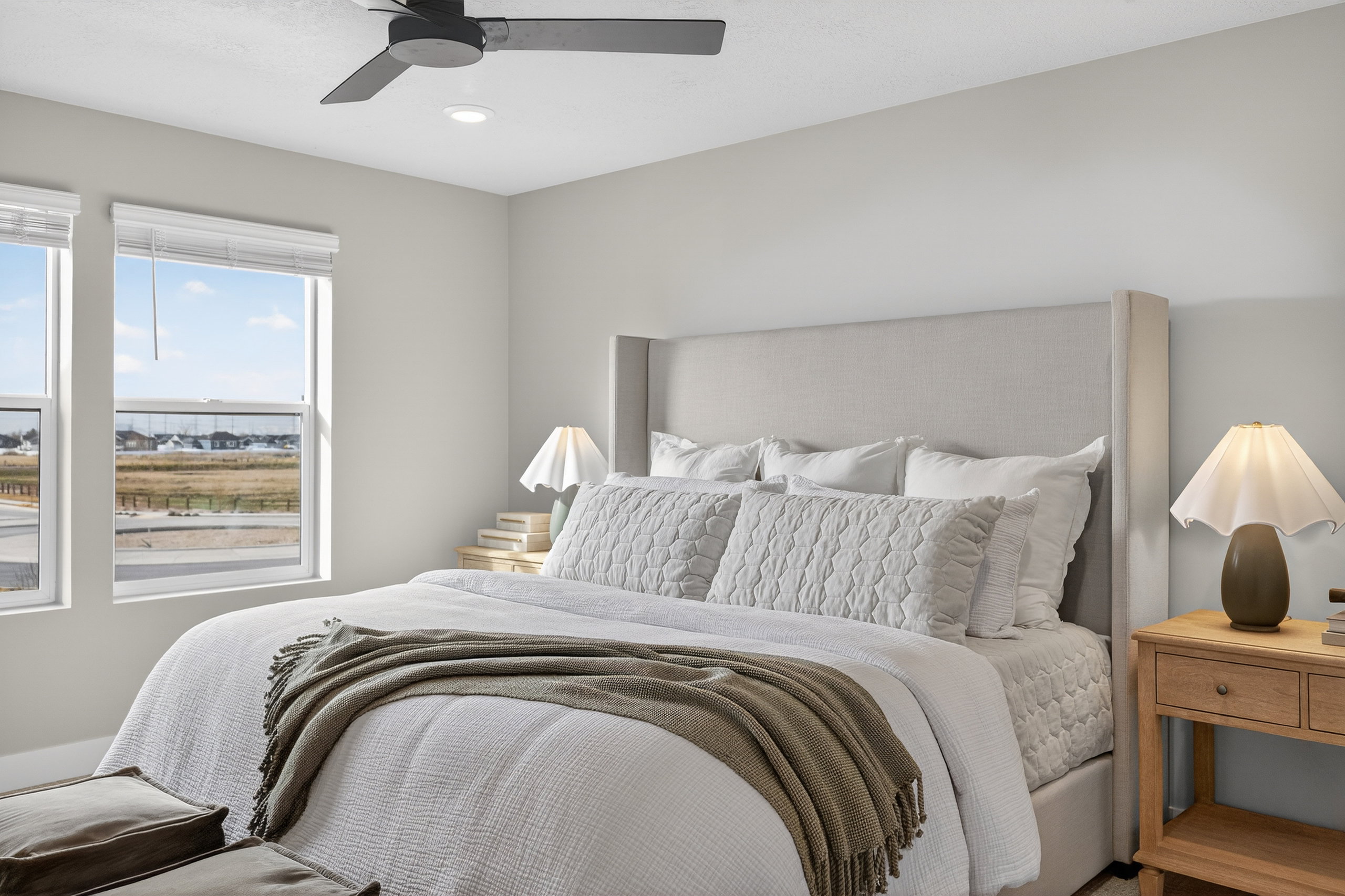 Bedroom featuring a light-toned upholstered headboard, a ceiling fan with integrated lighting, recessed lighting, and two windows