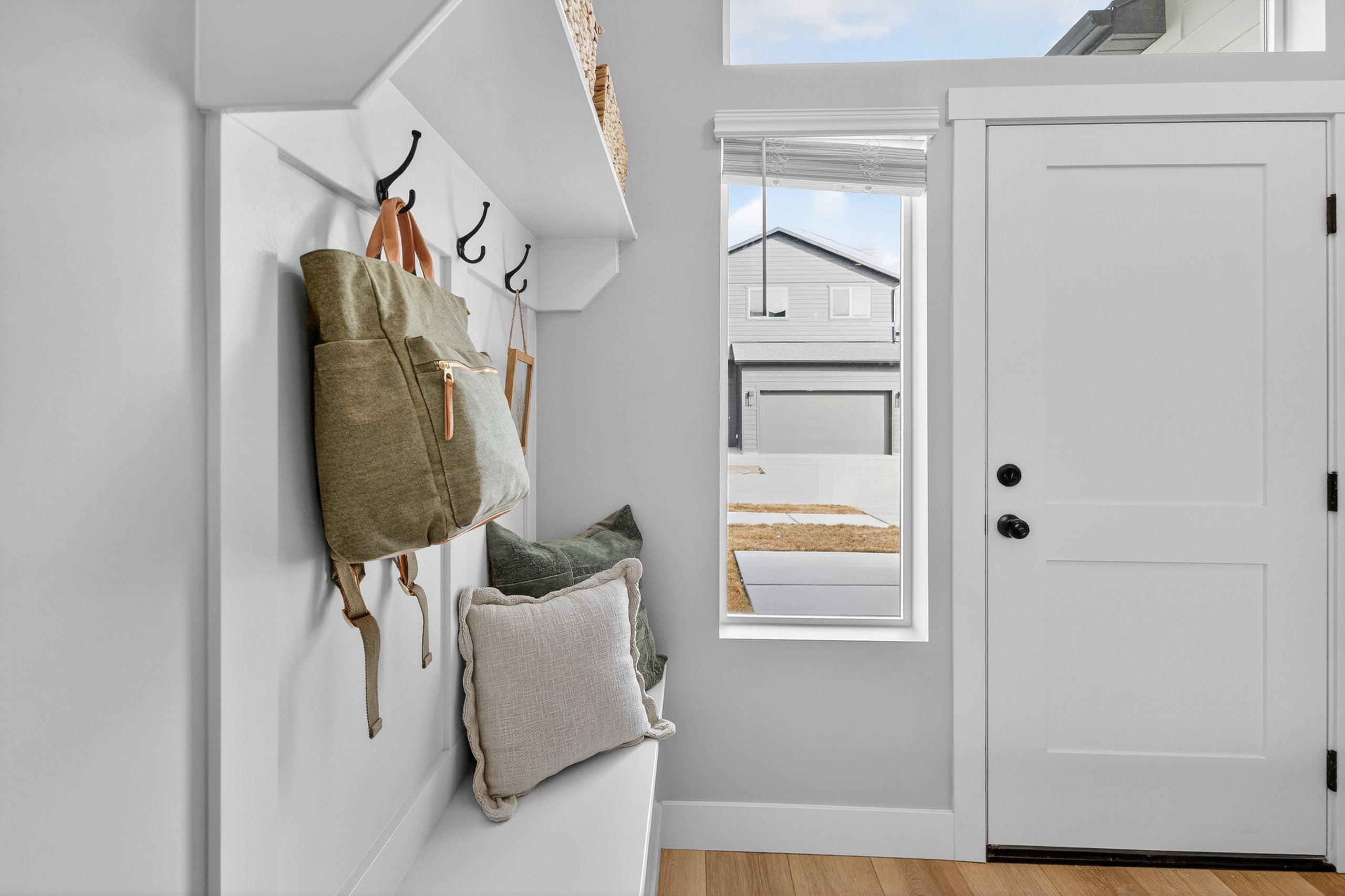 Entryway featuring a built-in bench with storage, board and batten wall paneling, and wall-mounted coat hooks