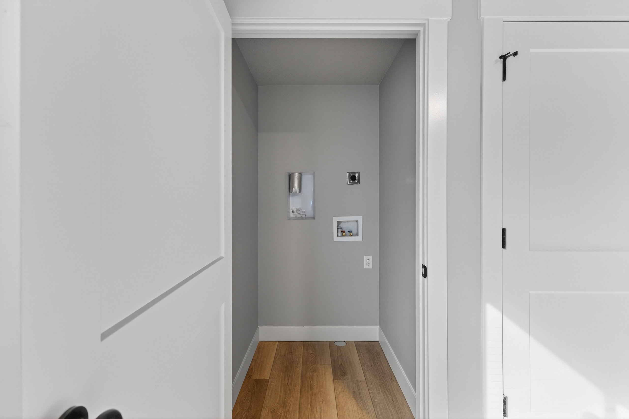 Dedicated utility area featuring wood-finish flooring and light gray walls