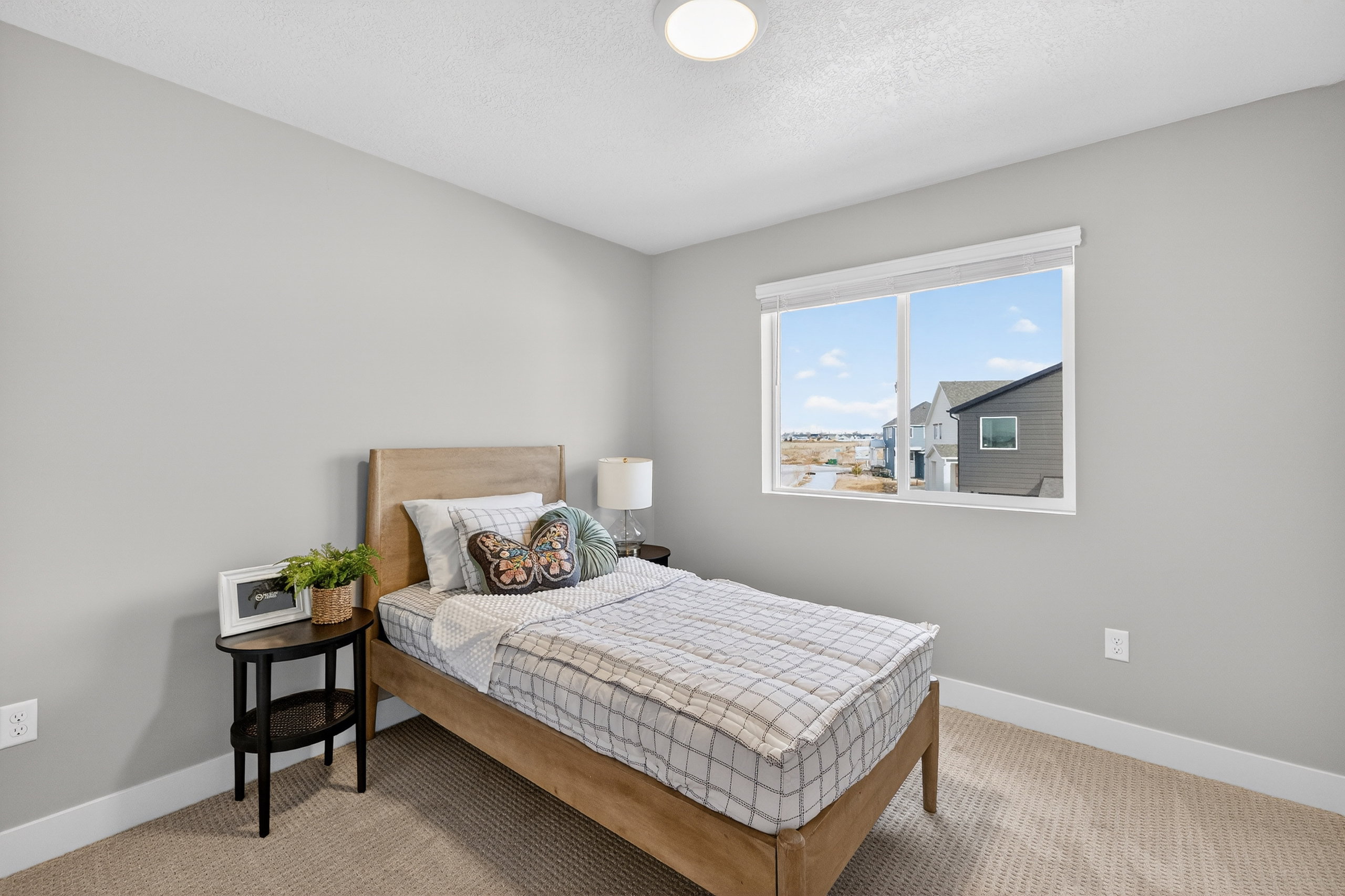 Bedroom featuring light grey walls, carpet flooring, and a large window with white trim