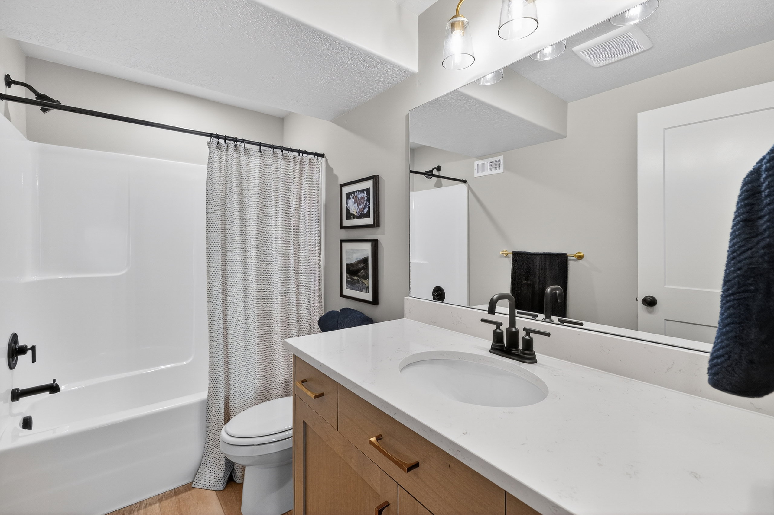 Bathroom featuring a white bathtub and shower combination with matte black fixtures