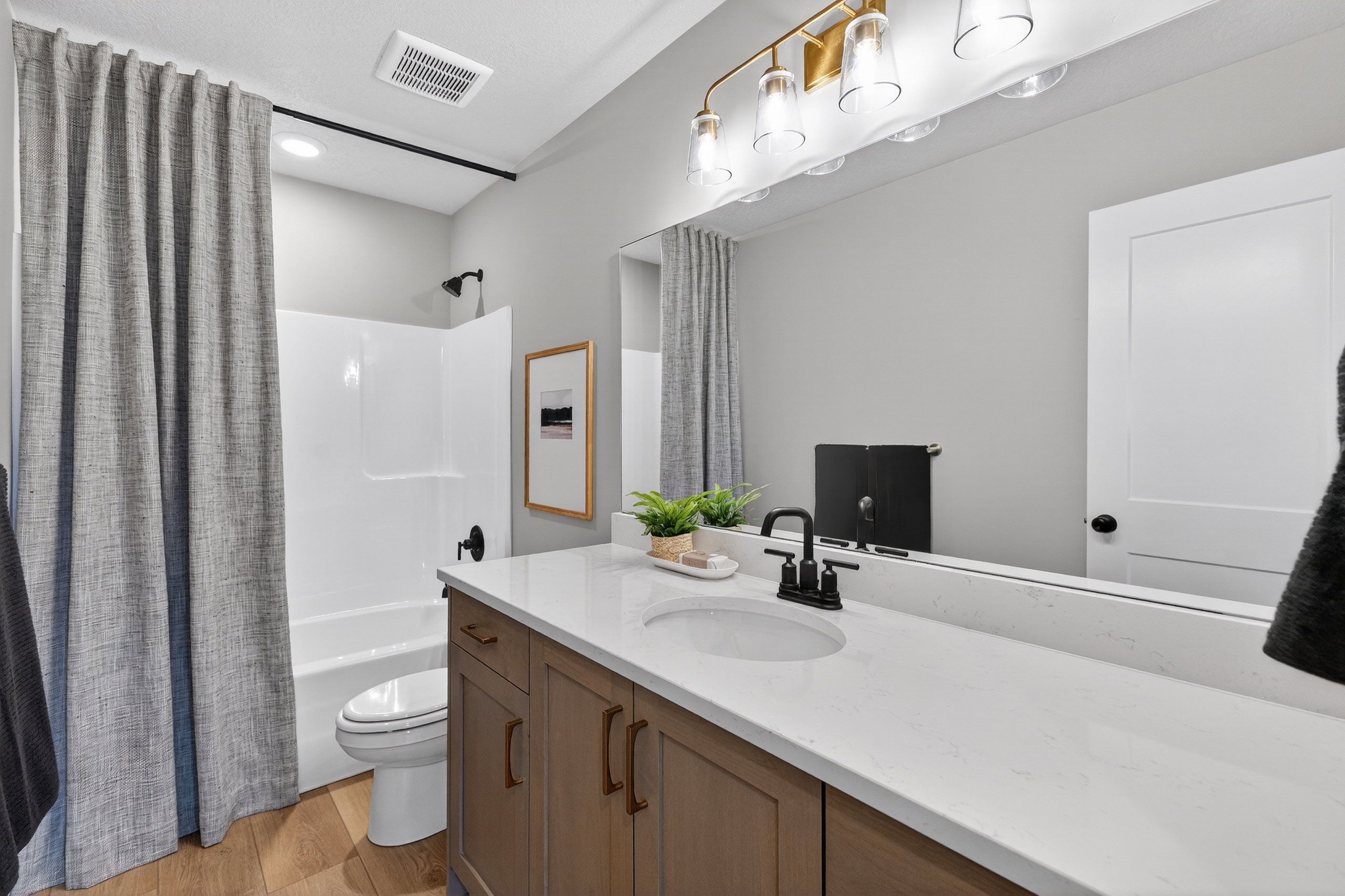 Modern bathroom featuring a wood-finish vanity with a single basin sink and white countertop