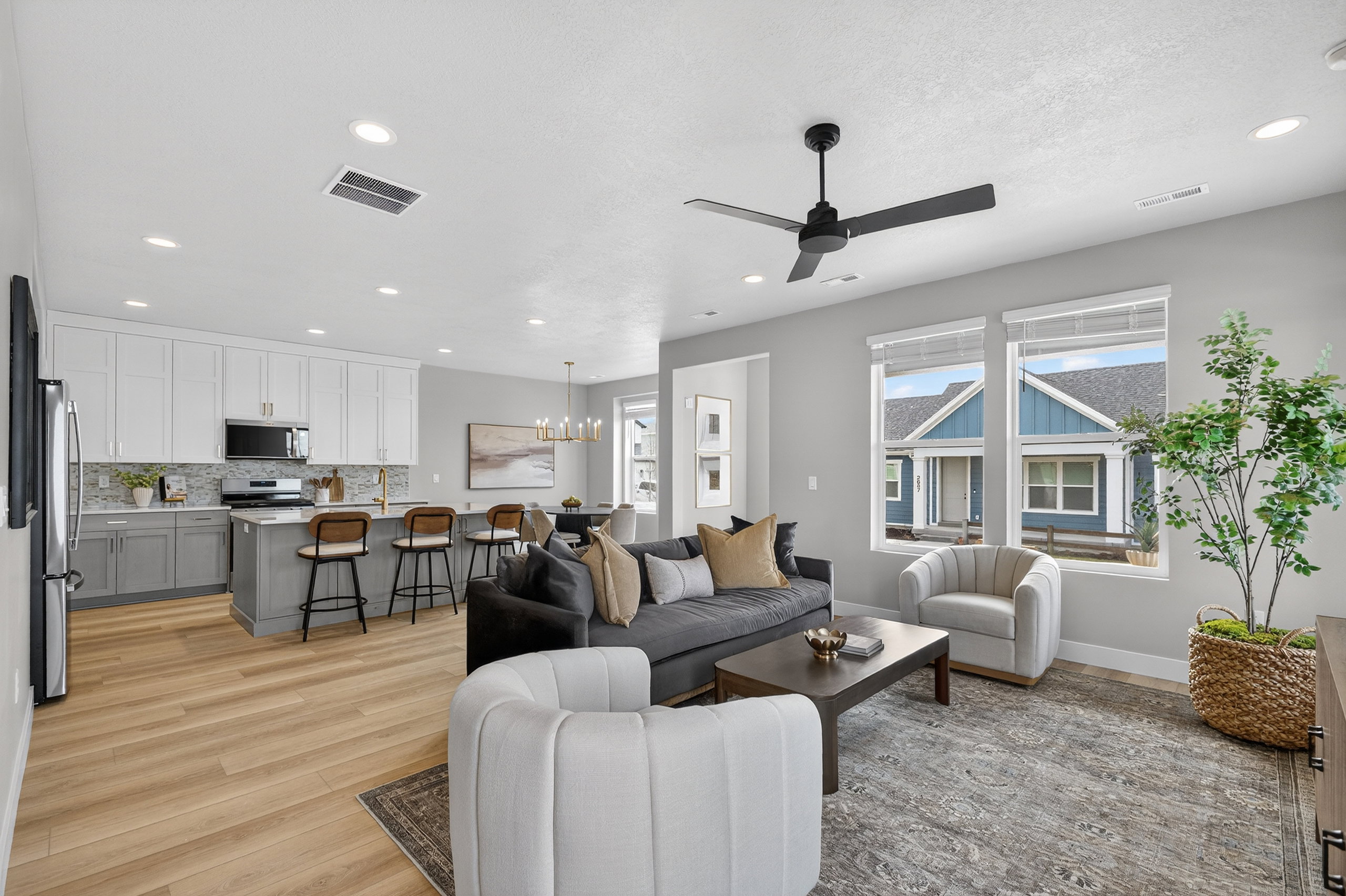 Open-concept living space featuring wood-finish flooring, a contemporary ceiling fan, and recessed lighting