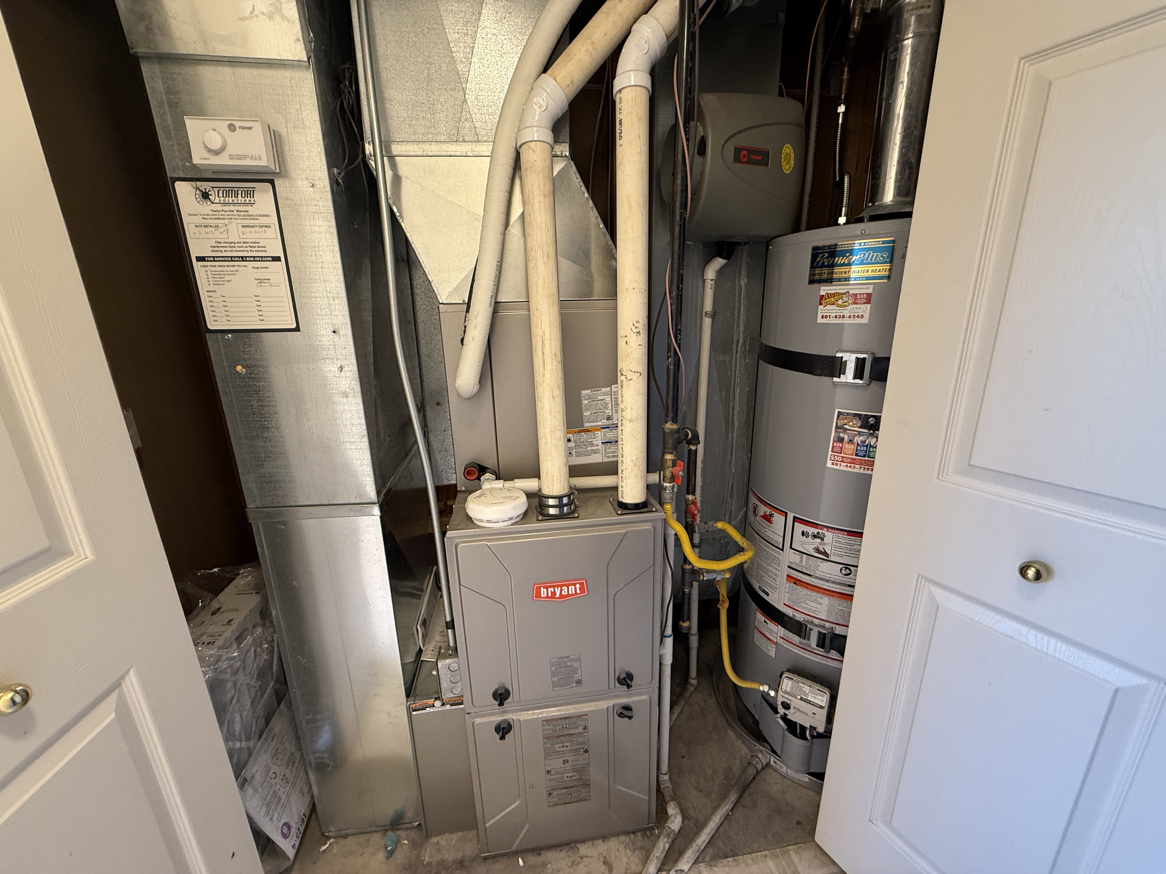 Utility closet featuring a Bryant furnace, water heater, and extensive ductwork