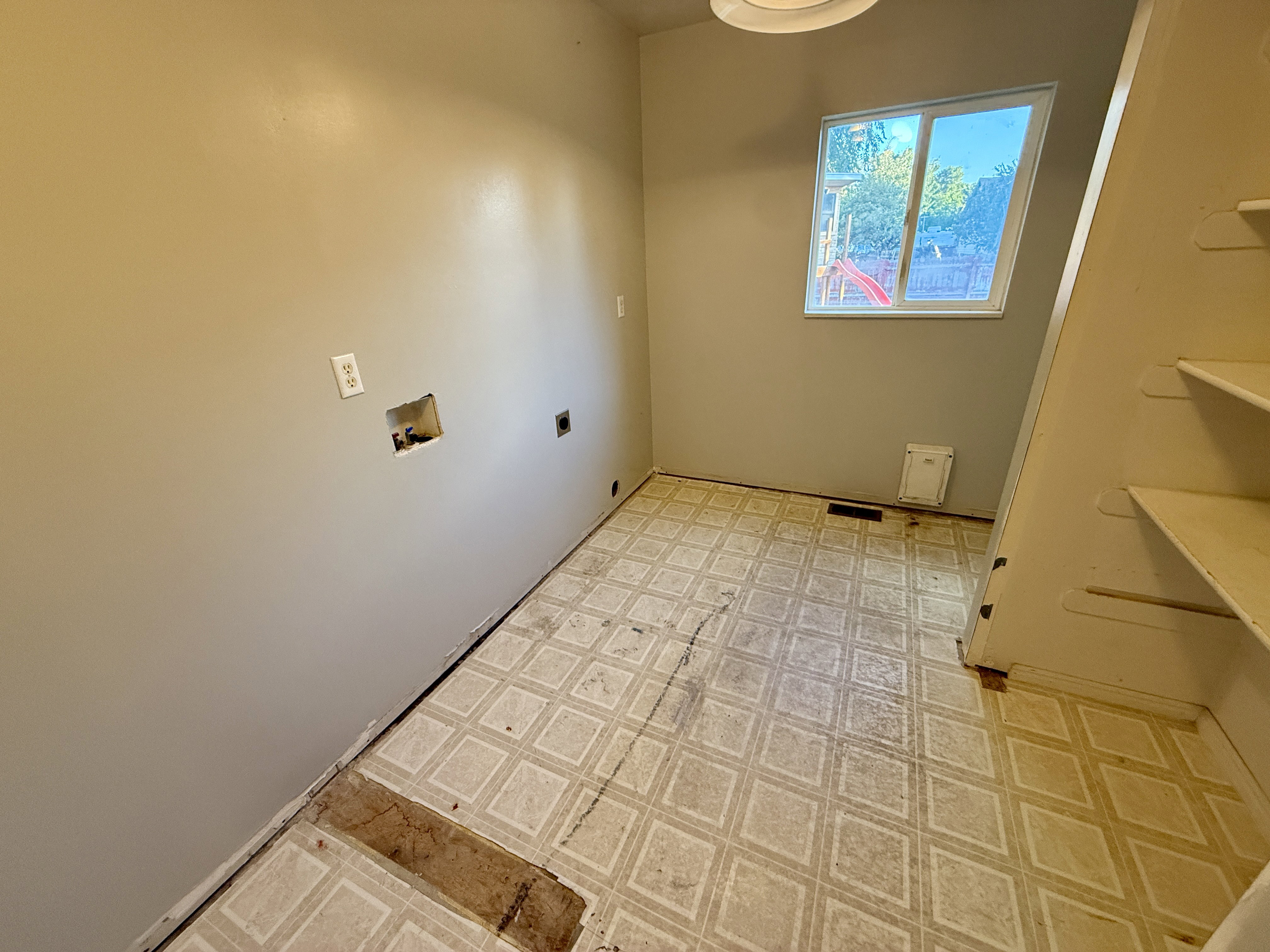 Utility room featuring a built-in shelving unit, a window, and connections for laundry appliances