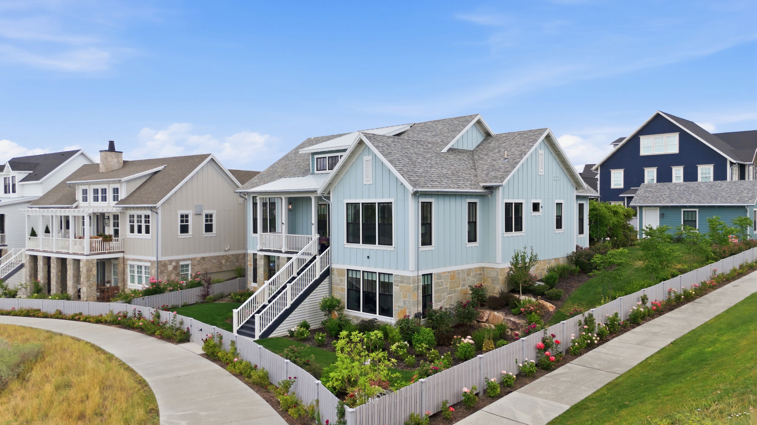 Light blue siding exterior featuring multiple dormers and a stone foundation