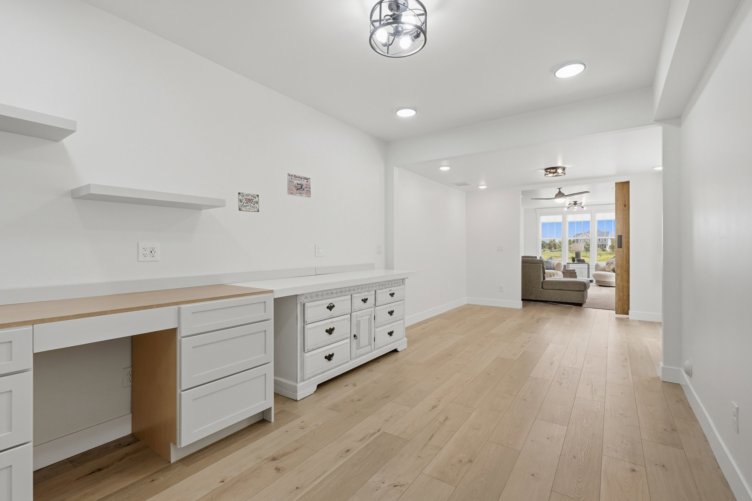 Versatile room featuring light wood-finish flooring, recessed lighting, and a contemporary semi-flush mount light fixture
