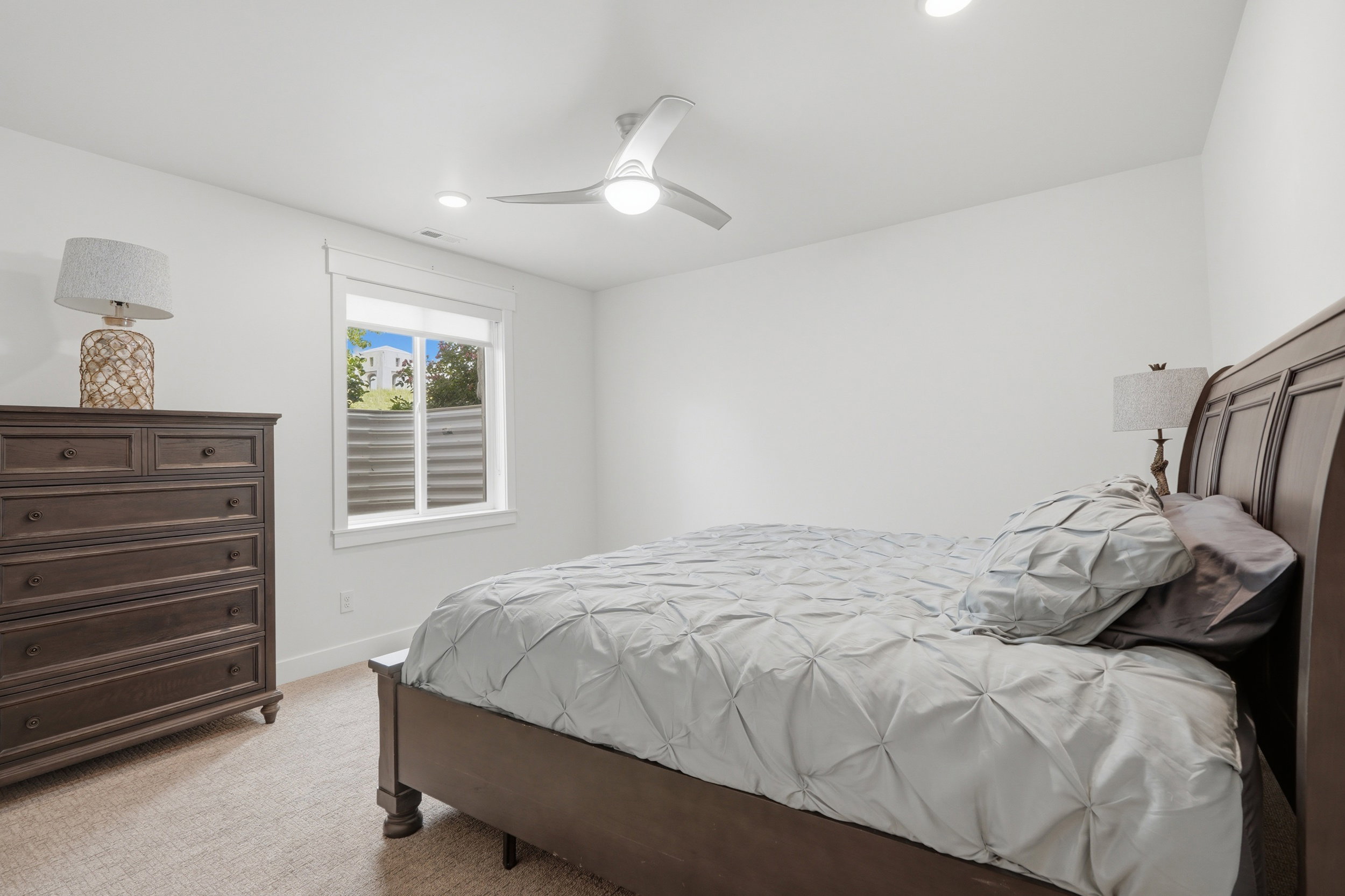 Bedroom featuring neutral carpet flooring, a ceiling fan with integrated lighting, recessed lighting, and a white-framed window