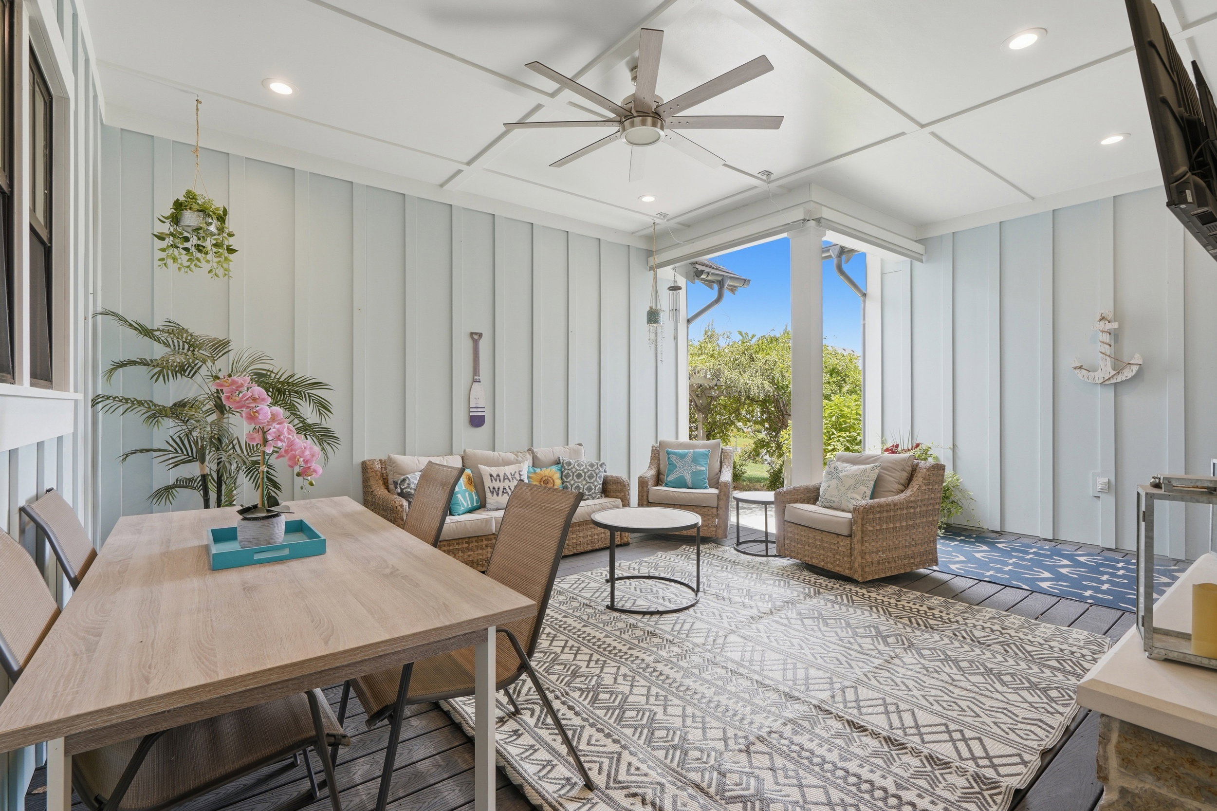 Covered outdoor patio featuring board and batten style walls and a coffered ceiling