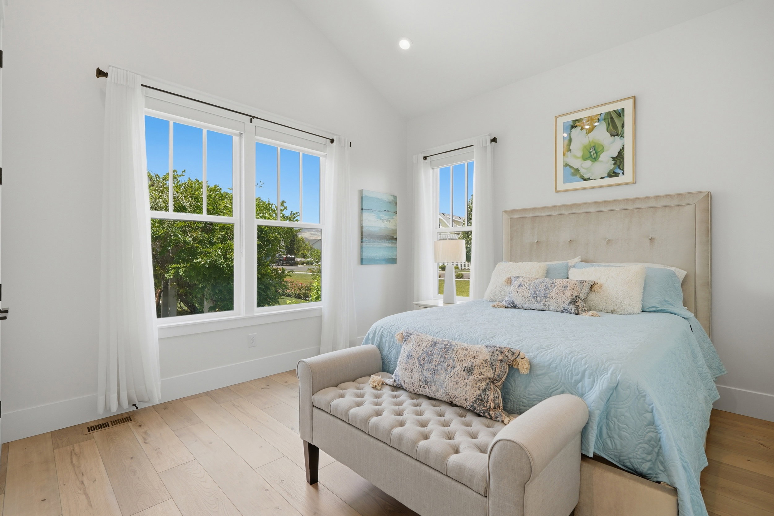 Room featuring light wood-finish flooring, white walls, and a vaulted ceiling with recessed lighting